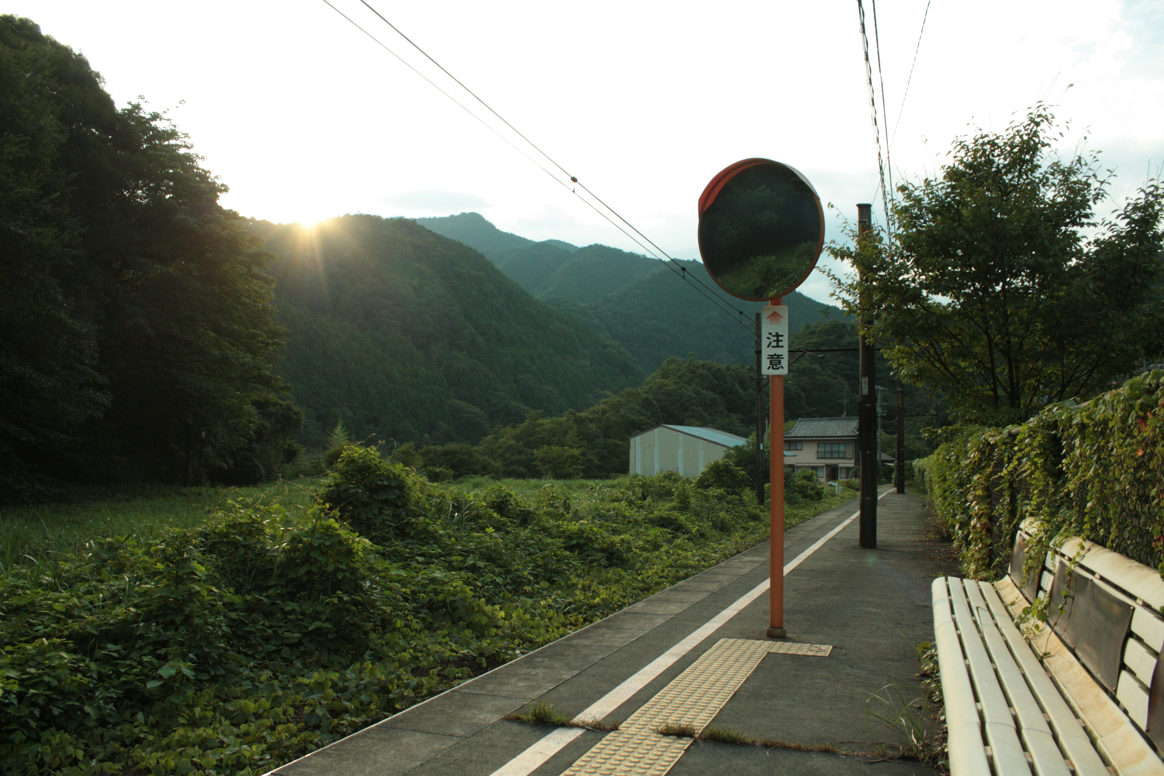 ชานชาลารถไฟที่เงียบสงบพร้อมภูเขาเป็นฉากหลัง