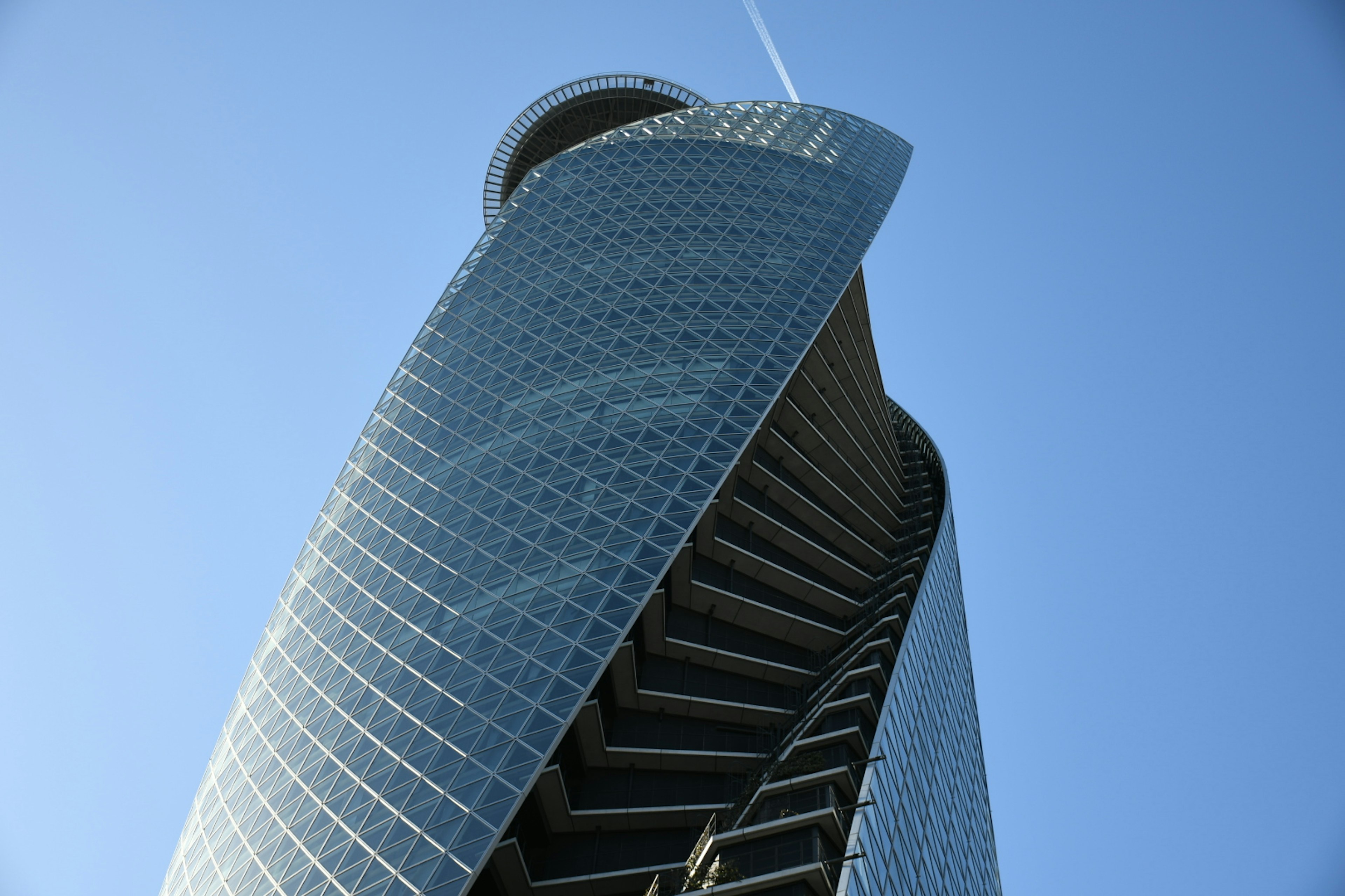 Gedung pencakar langit modern dengan desain unik menjulang di langit biru