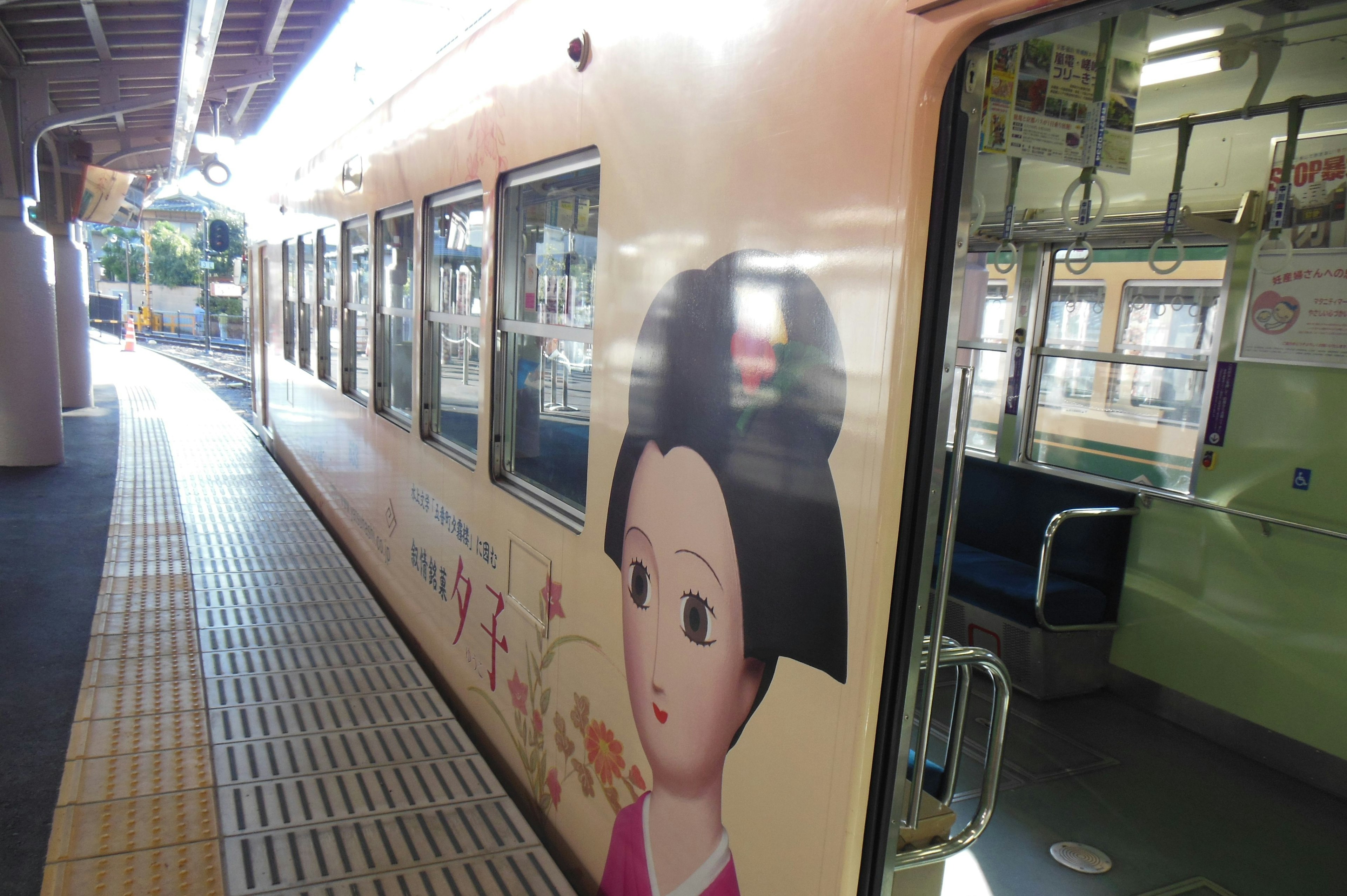 駅のプラットフォームに停車中の電車側面に描かれた可愛らしい女の子のイラスト