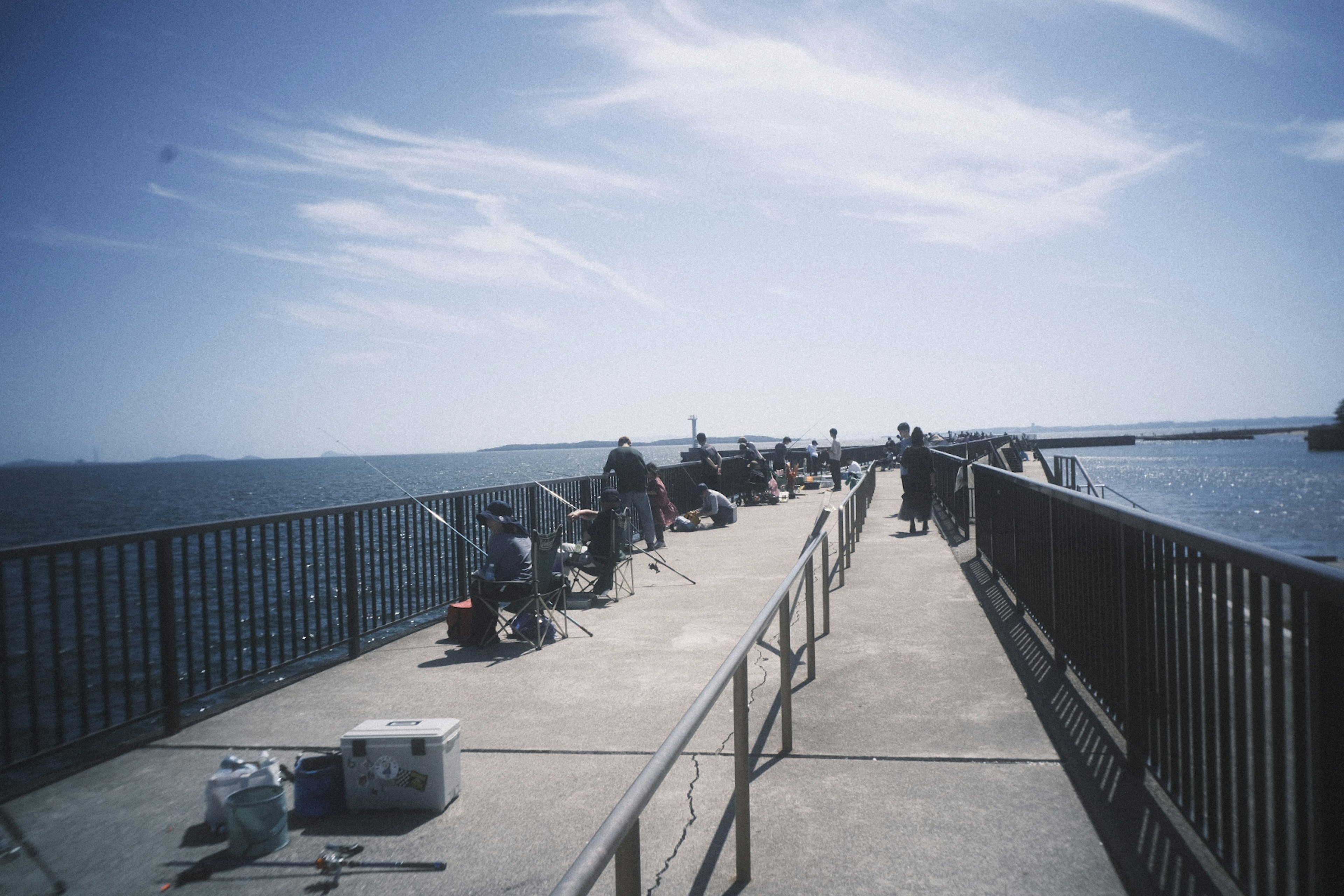 漁師が釣りをしている桟橋の風景 青空と海の景色