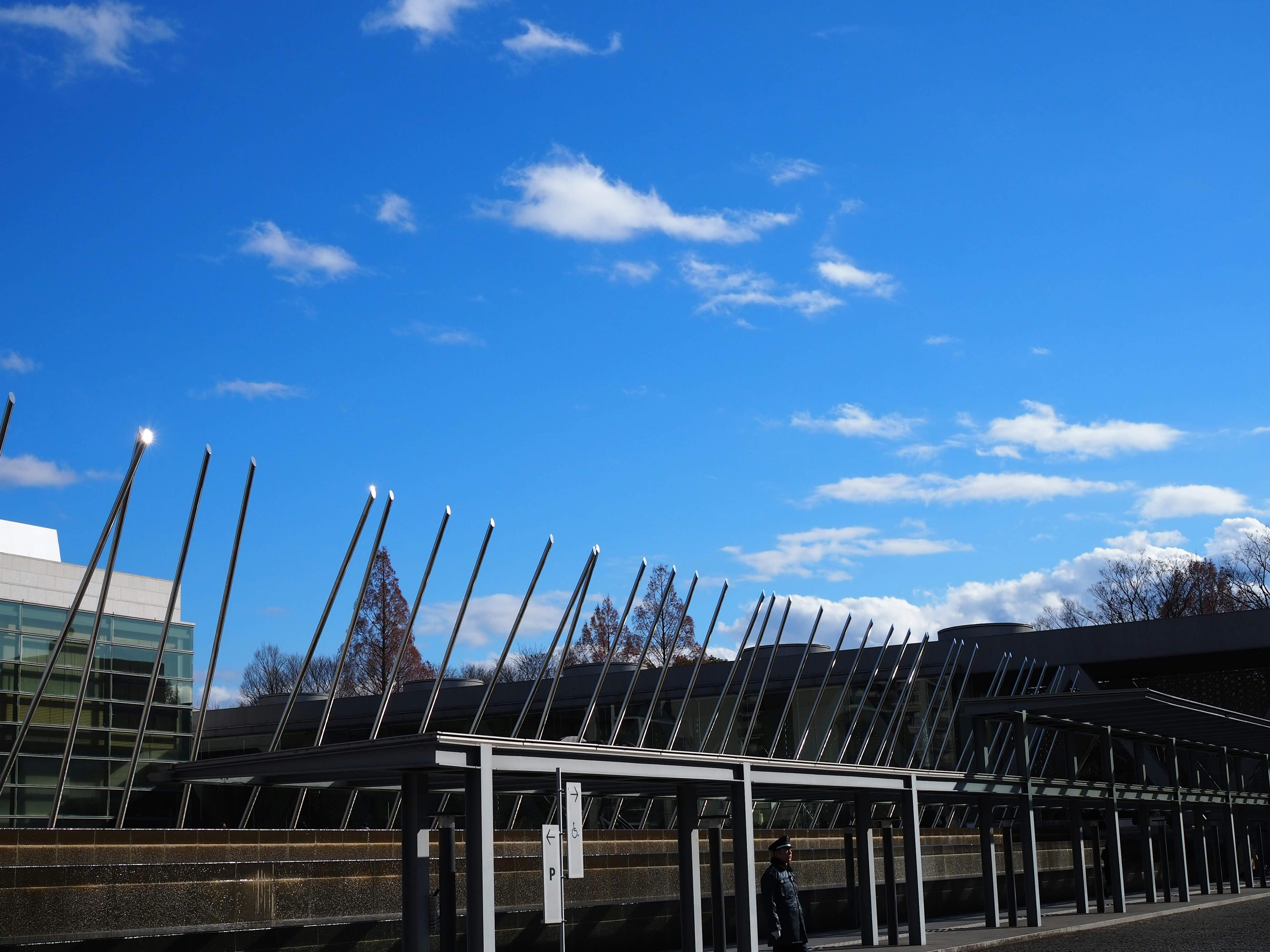 Bâtiment moderne sous un ciel bleu avec des poteaux métalliques inclinés