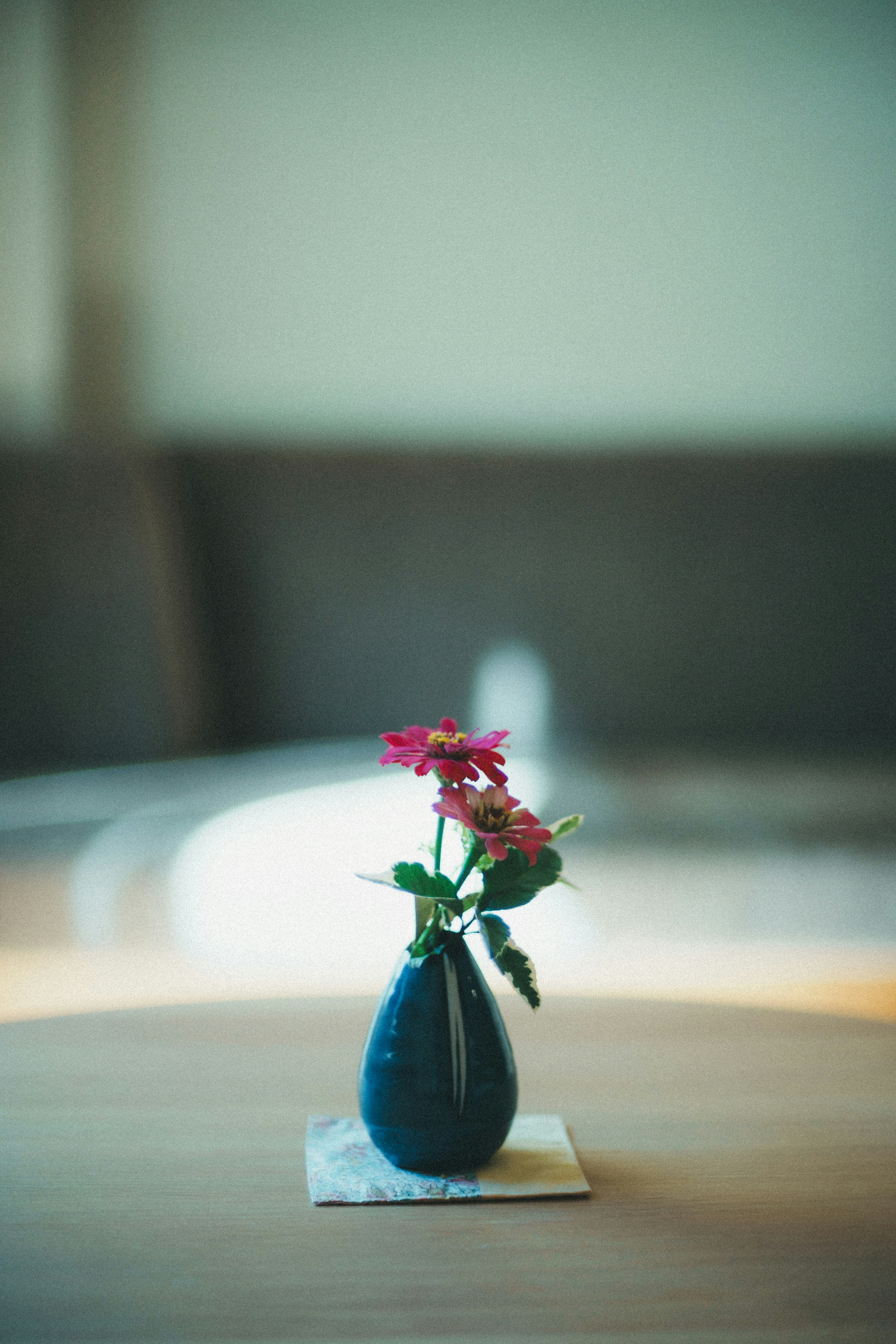 Un petit vase avec des fleurs colorées posé sur une table