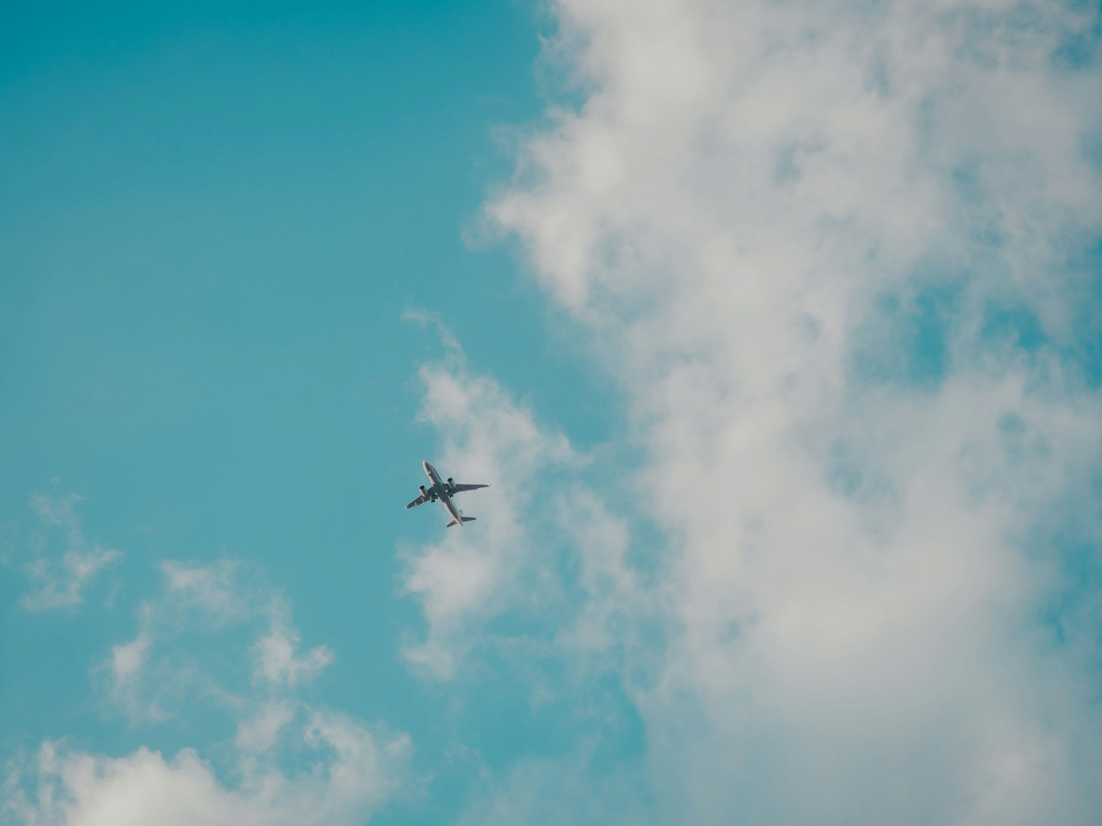 Flugzeug fliegt in einem blauen Himmel mit weißen Wolken