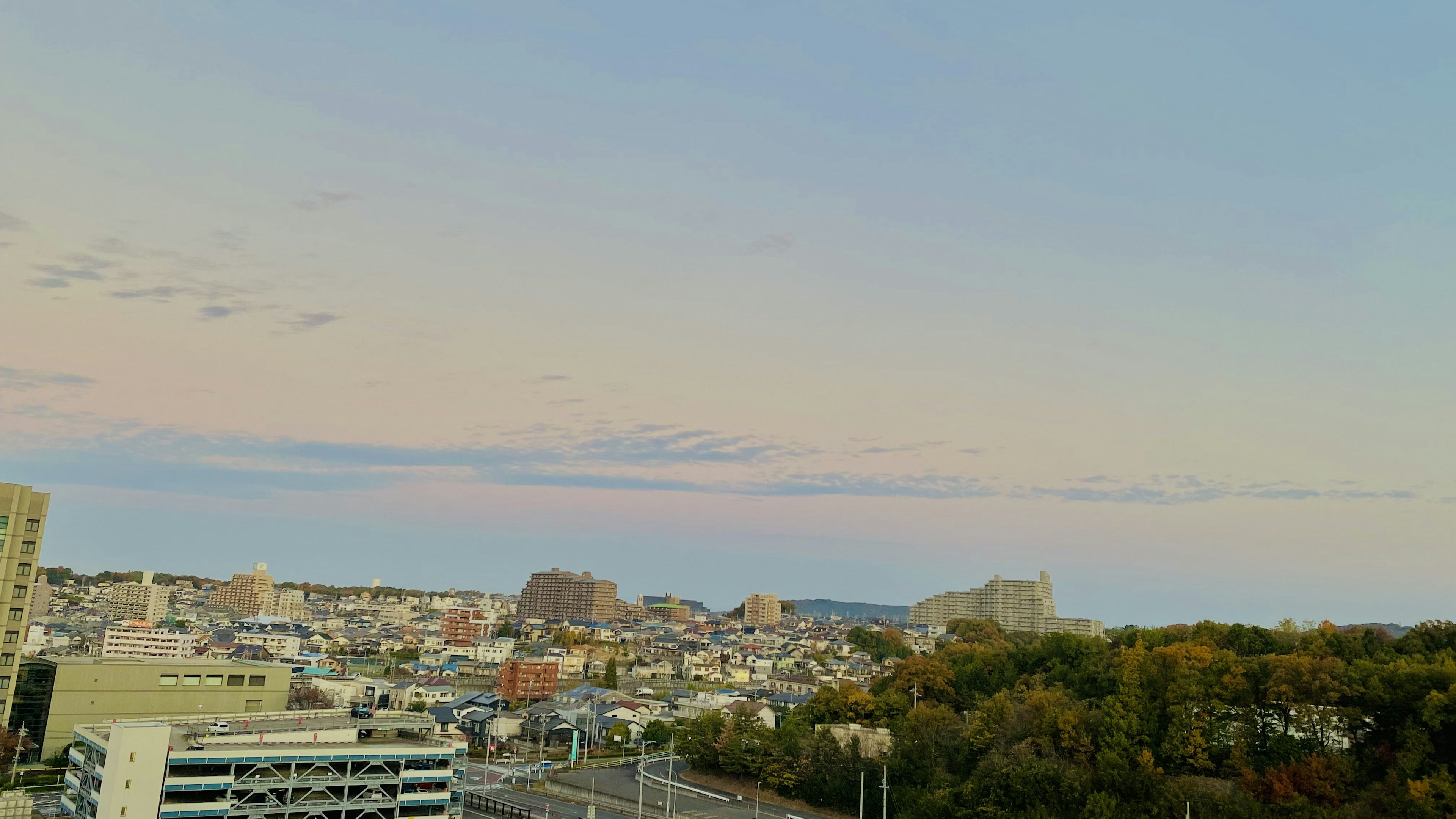 黃昏的城市景觀，柔和的雲朵和粉彩天空