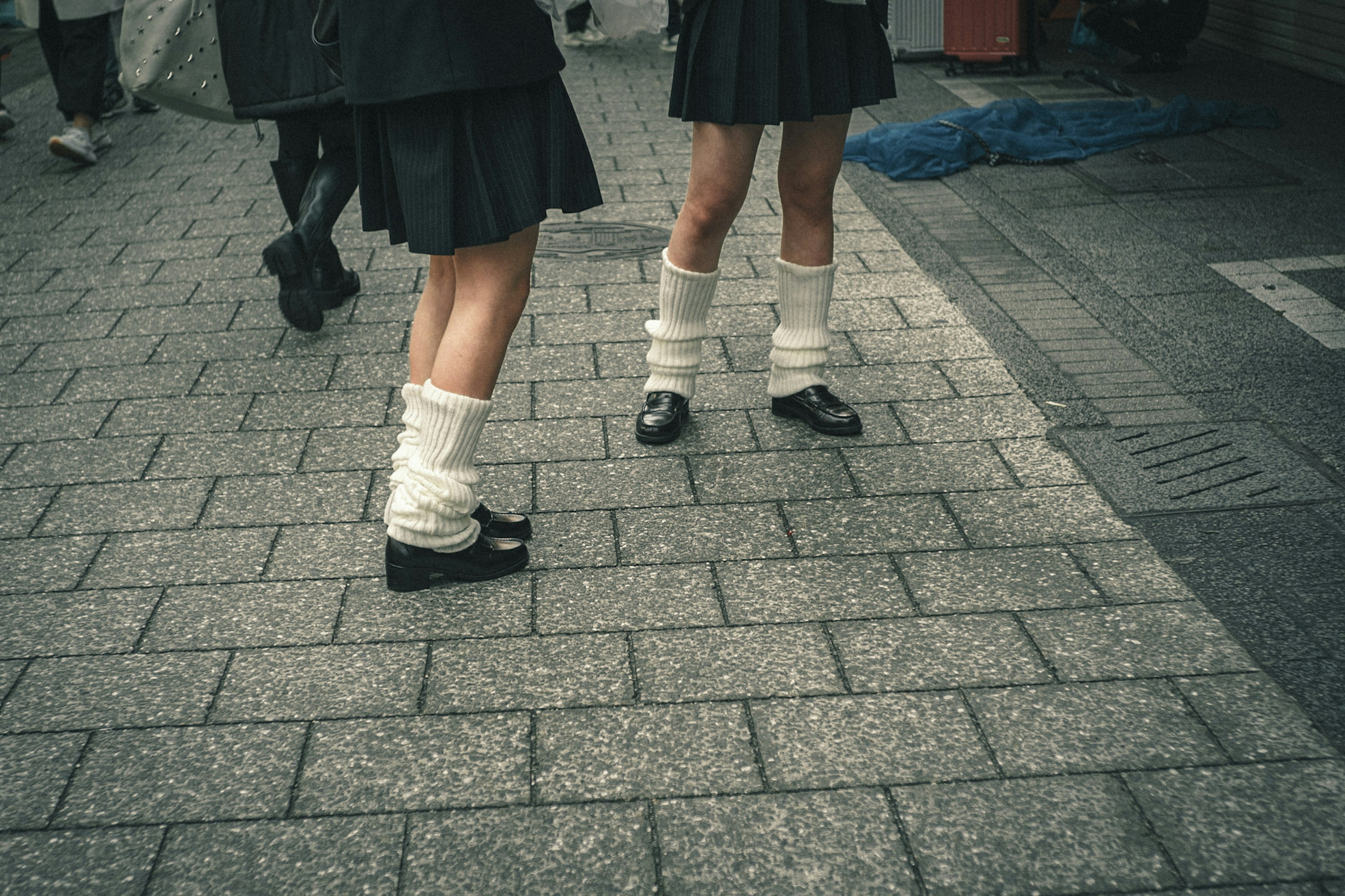 Primo piano di due paia di gambe in gonne e calzini bianchi