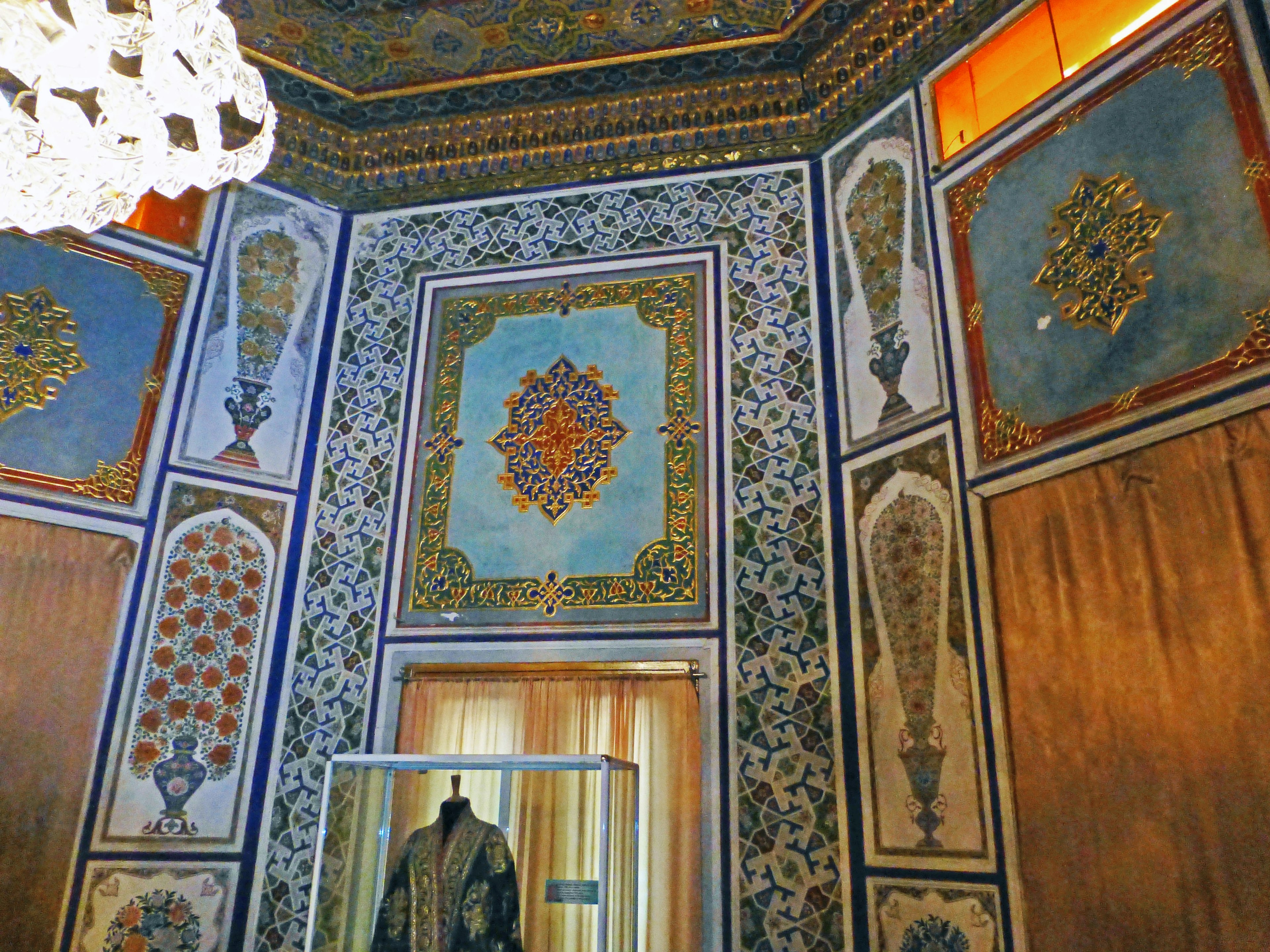 Interior de una habitación bellamente decorada con patrones azules y dorados en las paredes