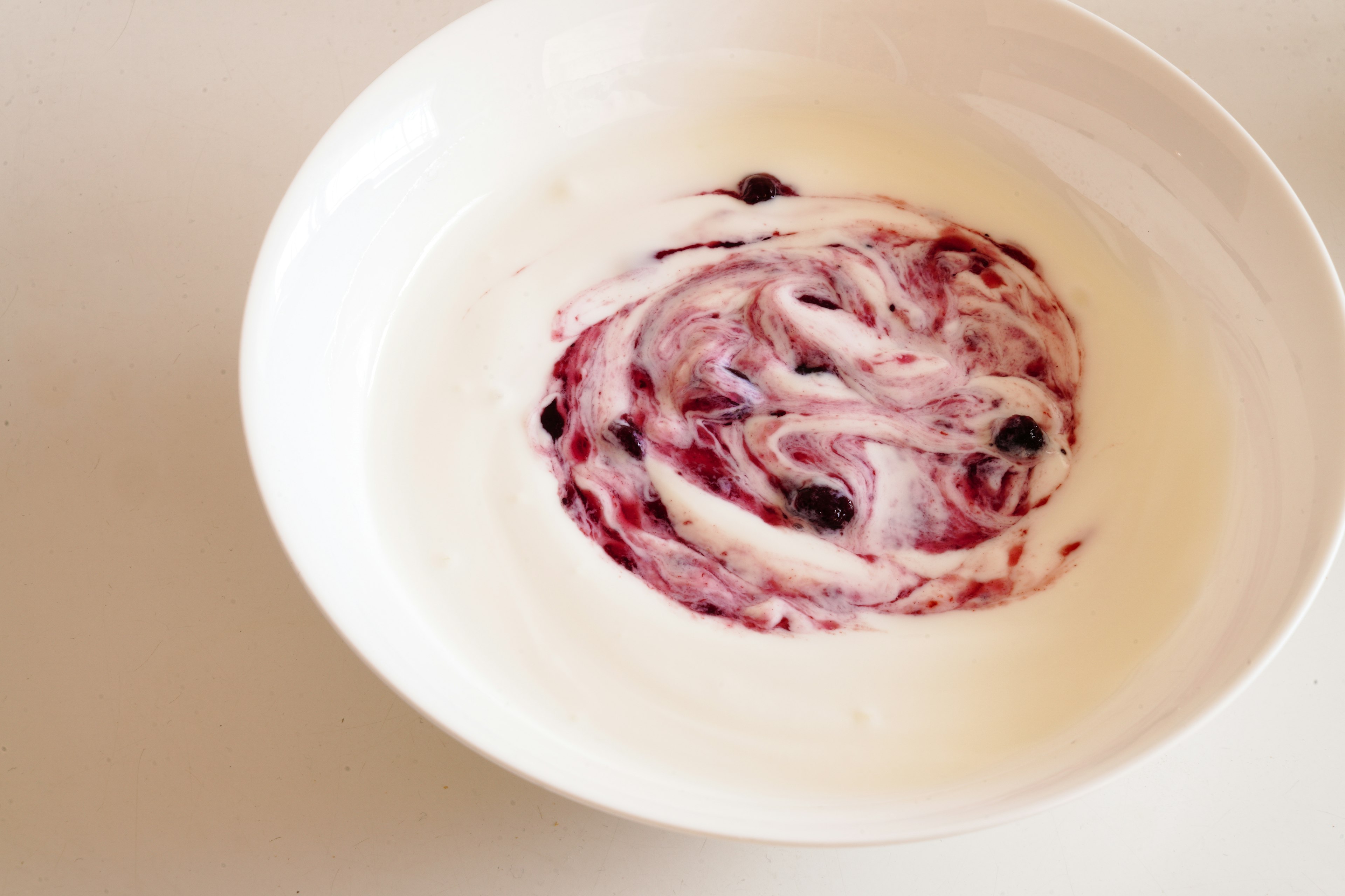 Swirled berry and cream mixture in a white bowl