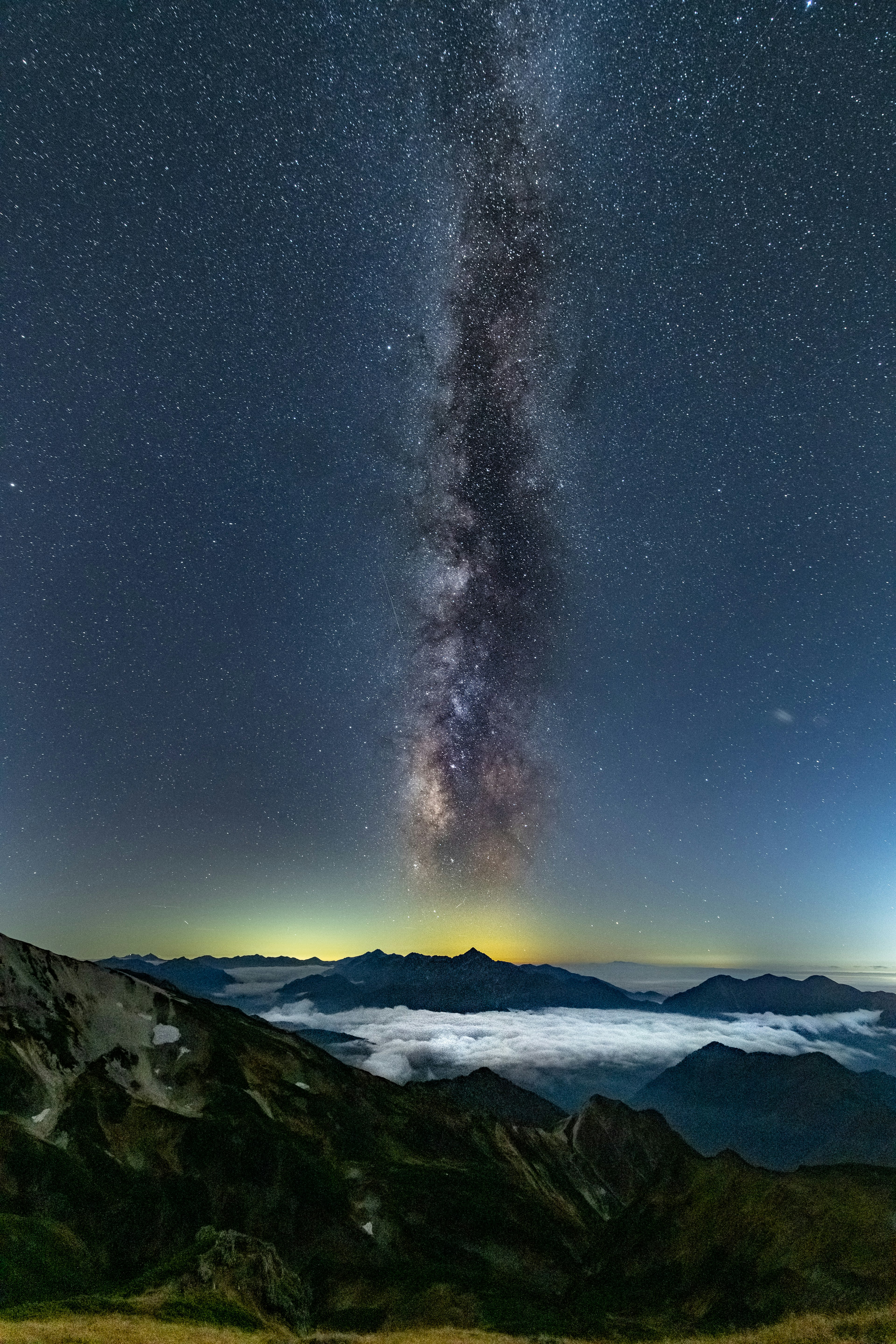 Beeindruckende Nachtszene mit Bergen und einem Wolkenmeer unter einem Sternenhimmel