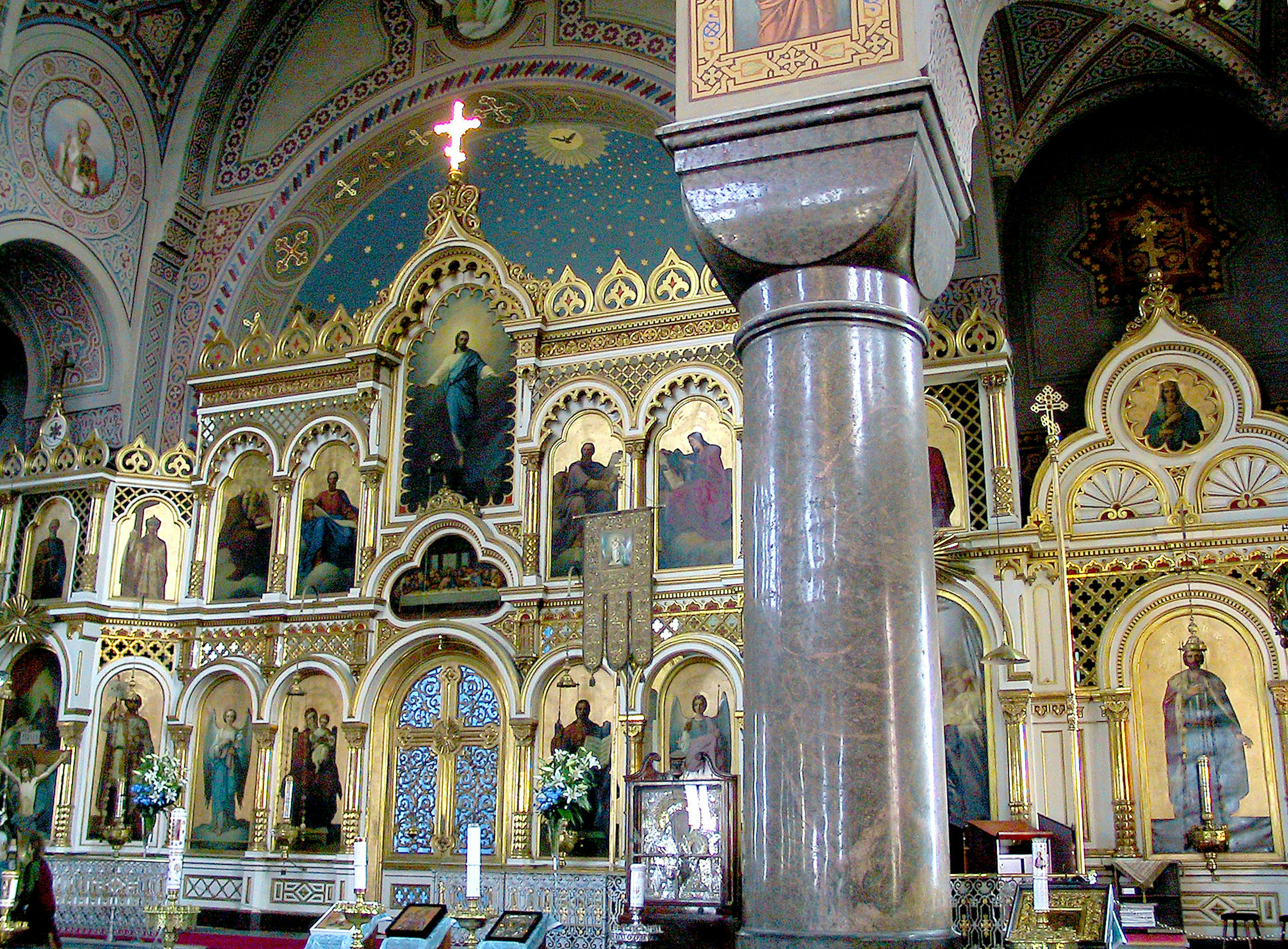 Intérieur d'une belle église avec des murs décoratifs et des colonnes présentant des icônes et des détails dorés