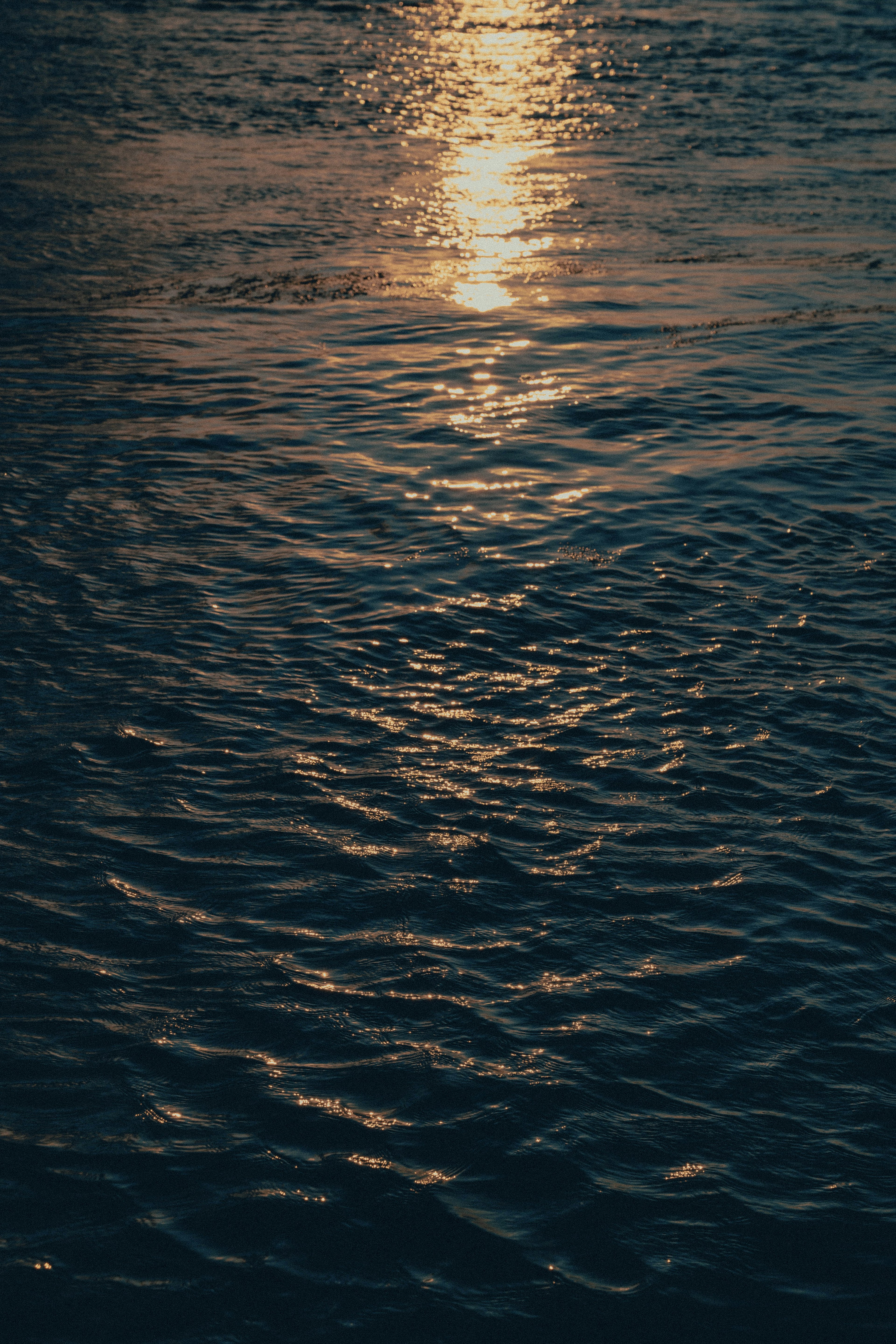 Bella scena del riflesso del tramonto sulla superficie dell'acqua con increspature