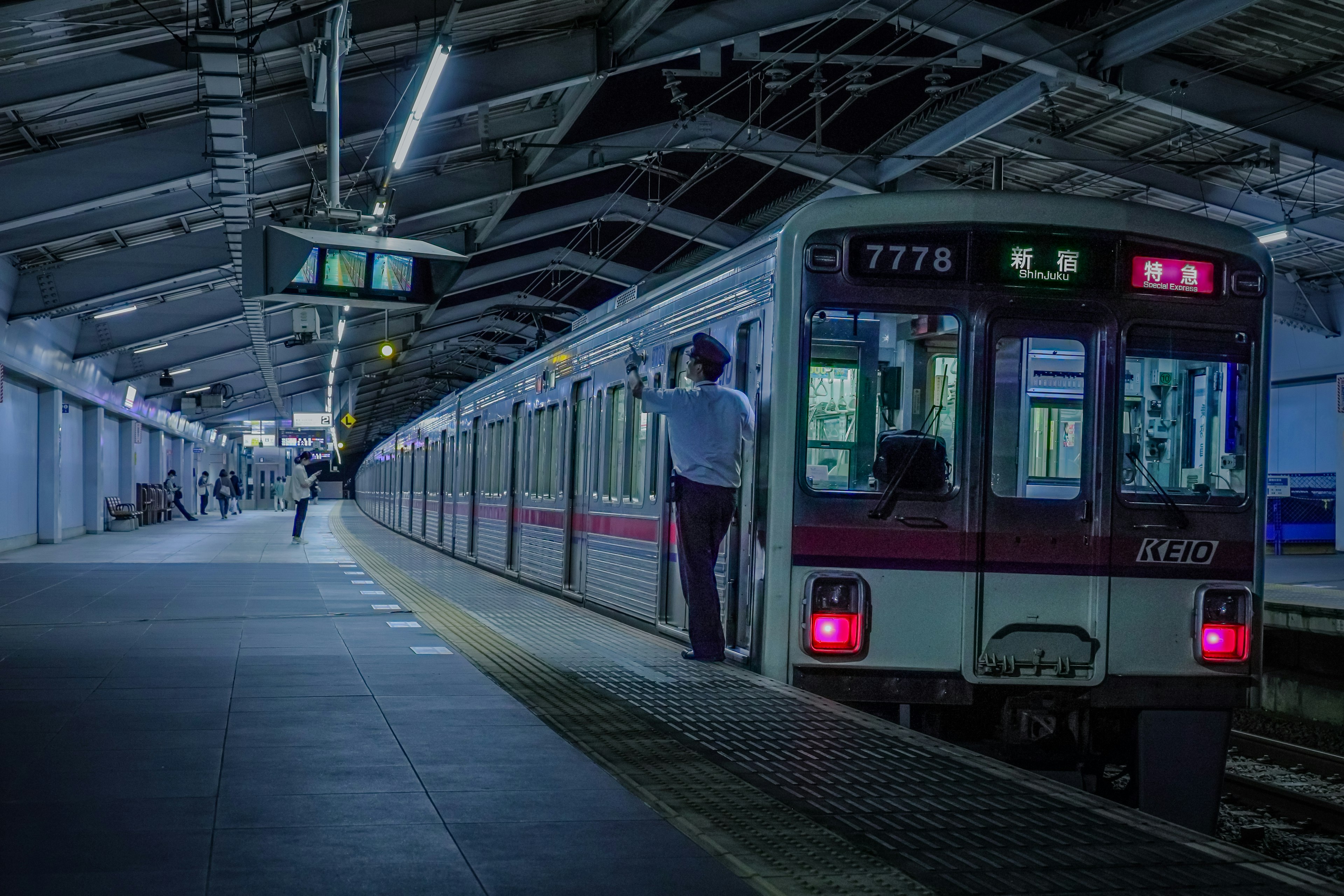 Train stopped at a station platform with a passenger