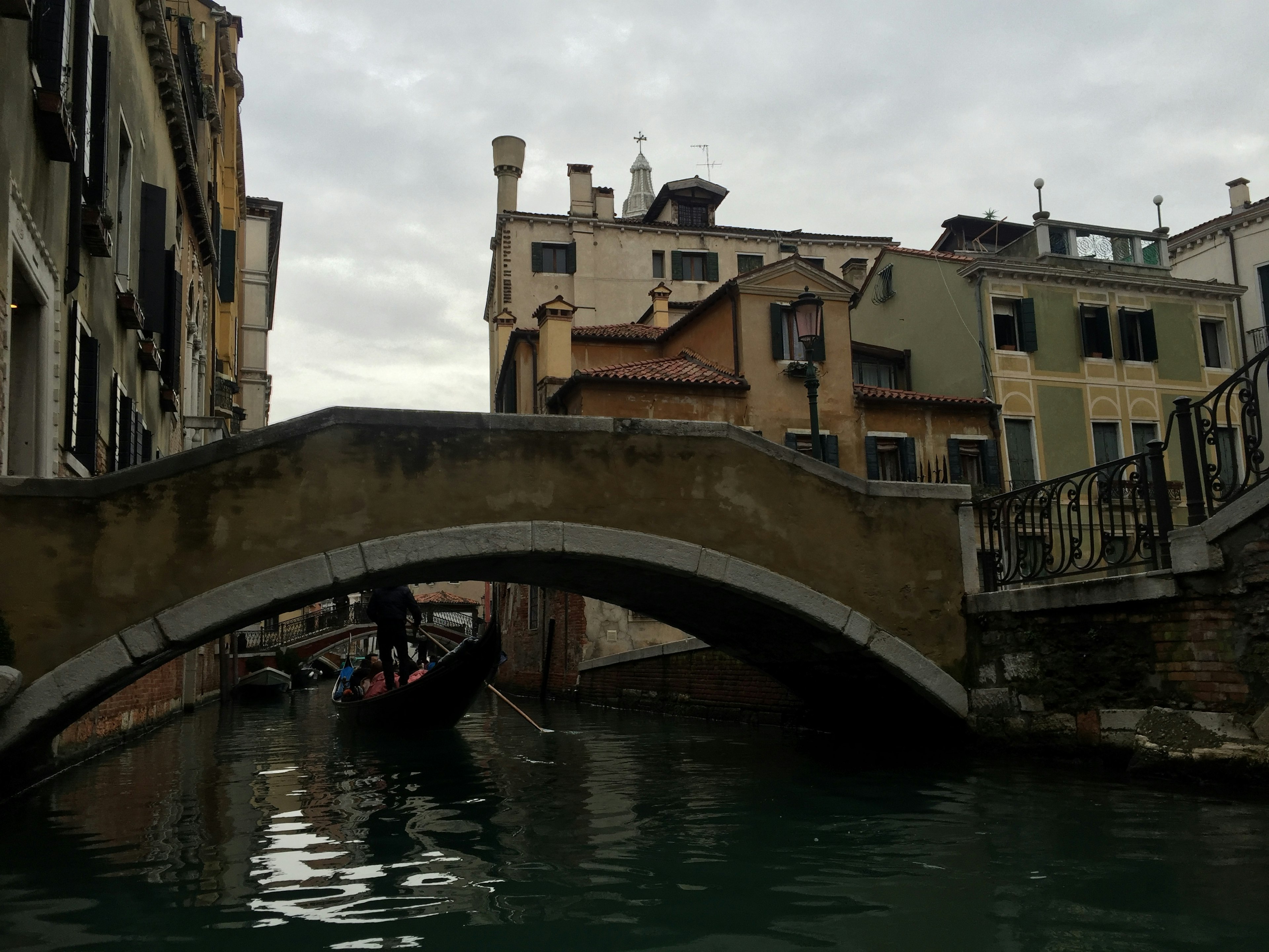 Antico ponte in pietra su un canale con edifici circostanti