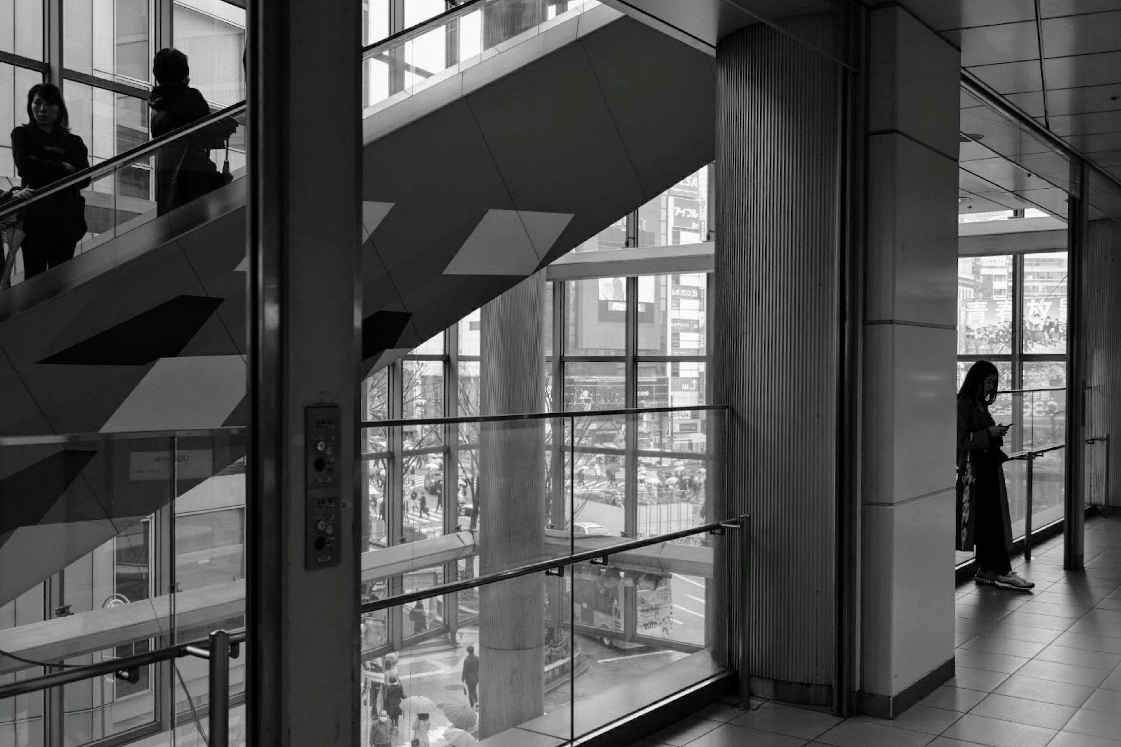 Vista interior de un edificio moderno con escaleras y paredes de vidrio personas usando las escaleras