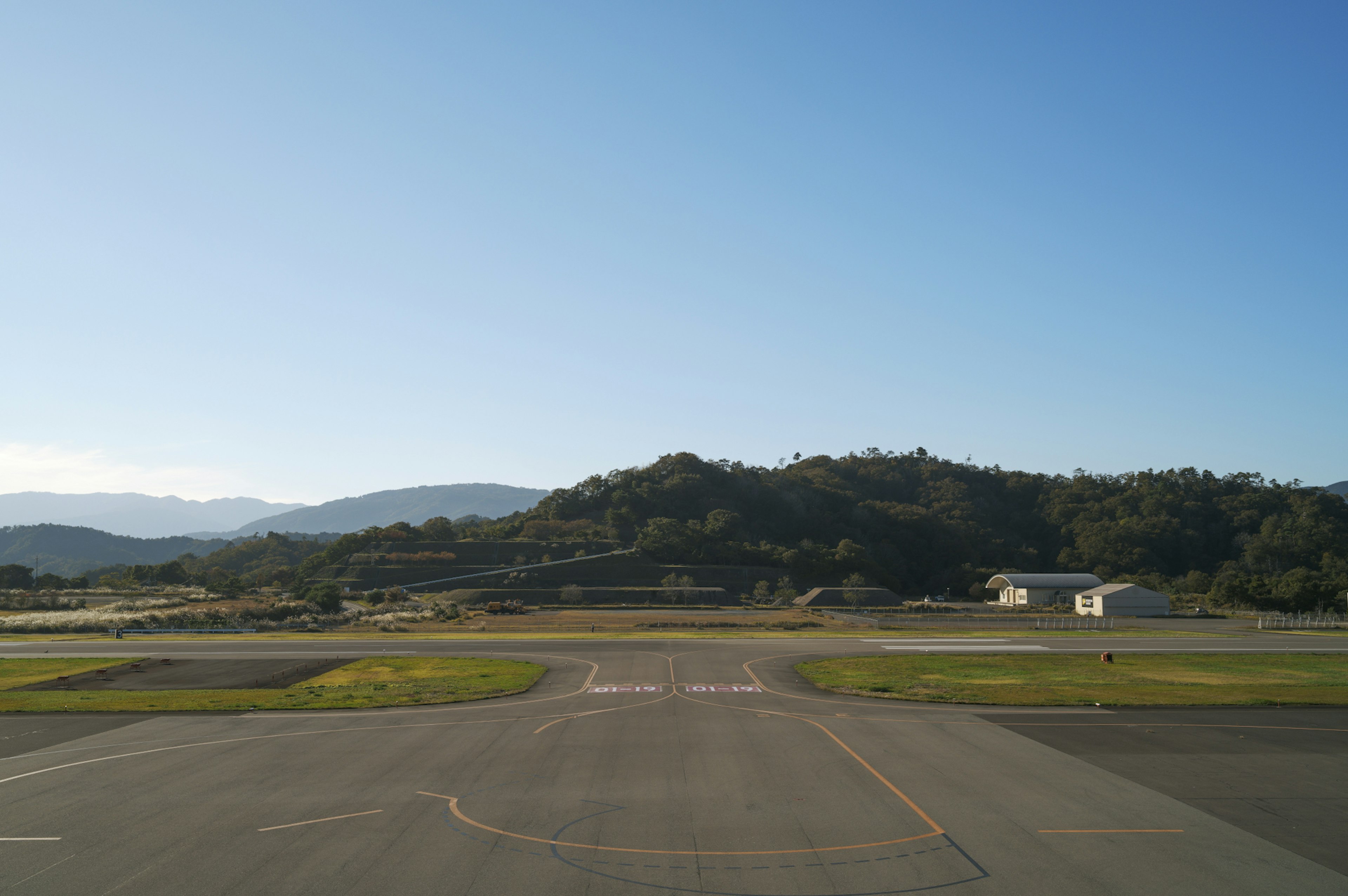 Panoramablick auf eine Landebahn mit blauem Himmel und fernen Bergen