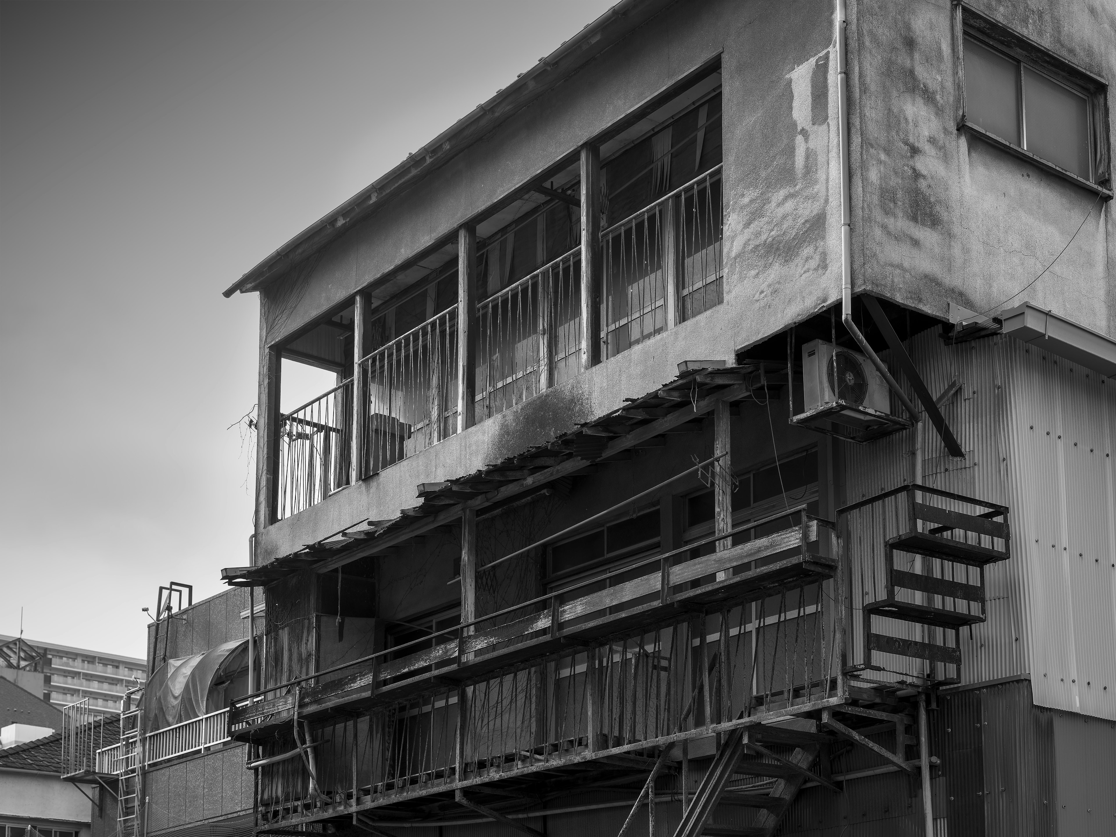 Photo en noir et blanc d'un vieux bâtiment avec un escalier visible