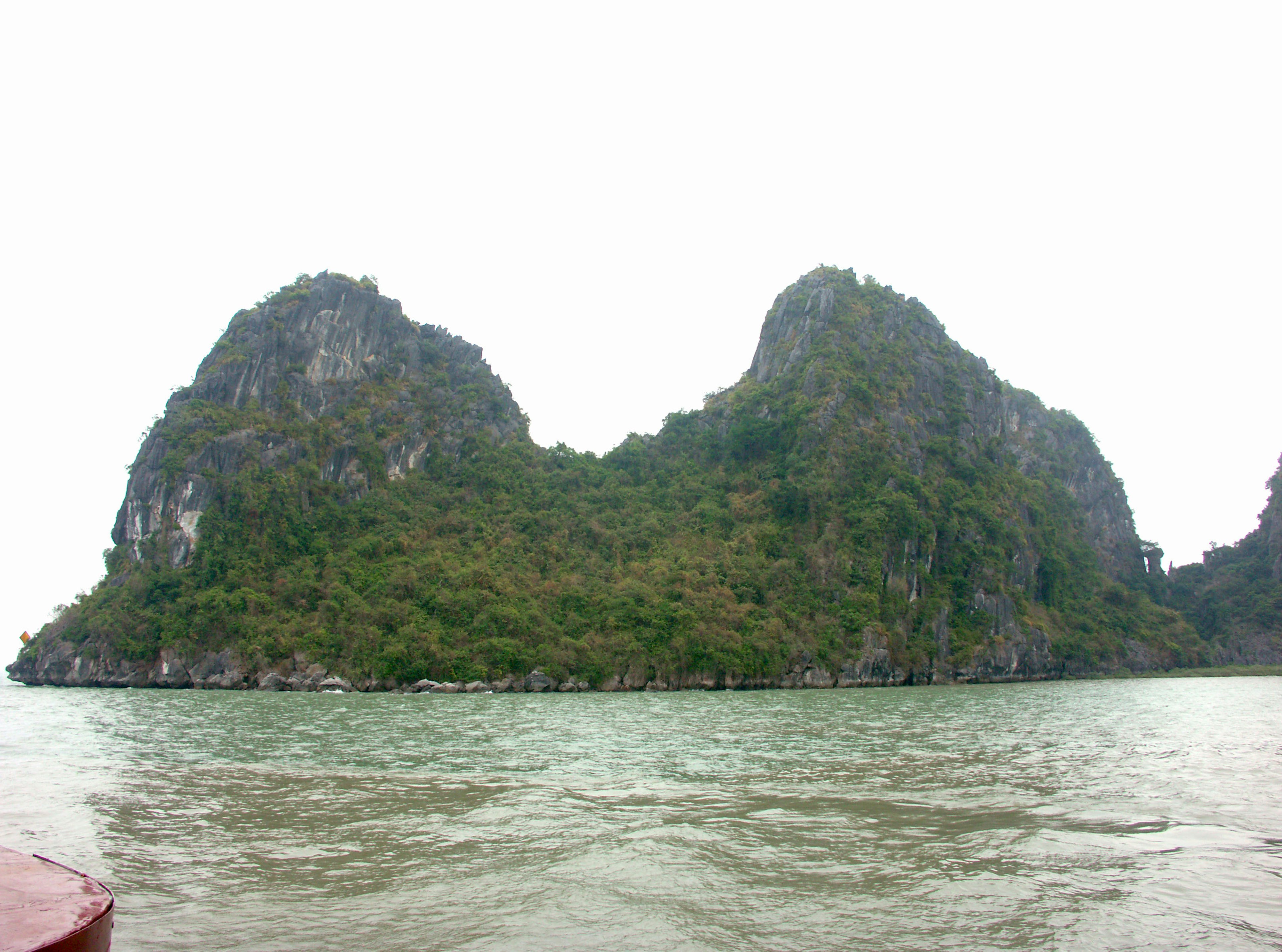 Panoramablick auf zwei grüne Berge, die aus dem Wasser ragen