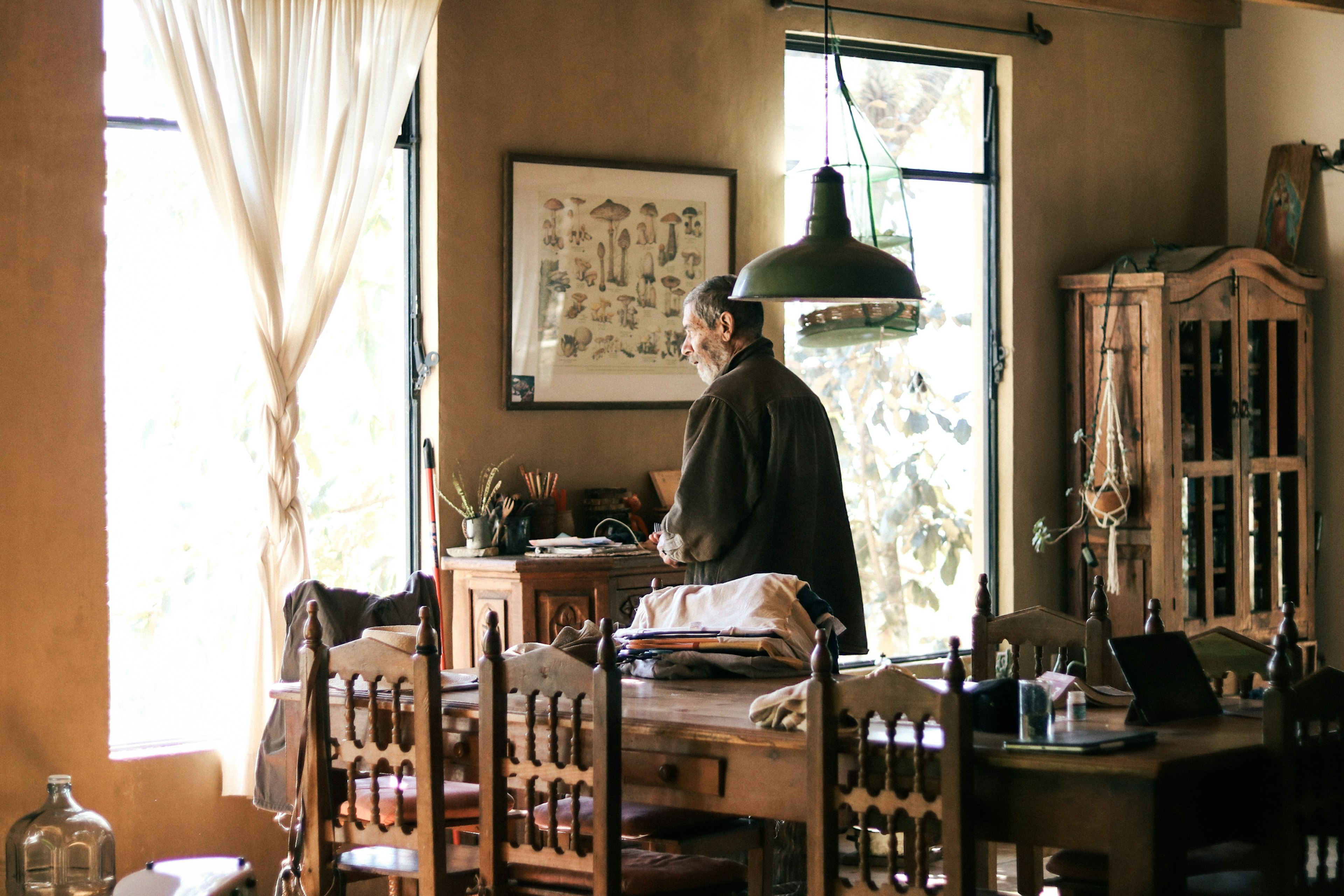 Personne travaillant dans un espace intérieur confortable avec une lumière naturelle provenant de la fenêtre et des meubles en bois