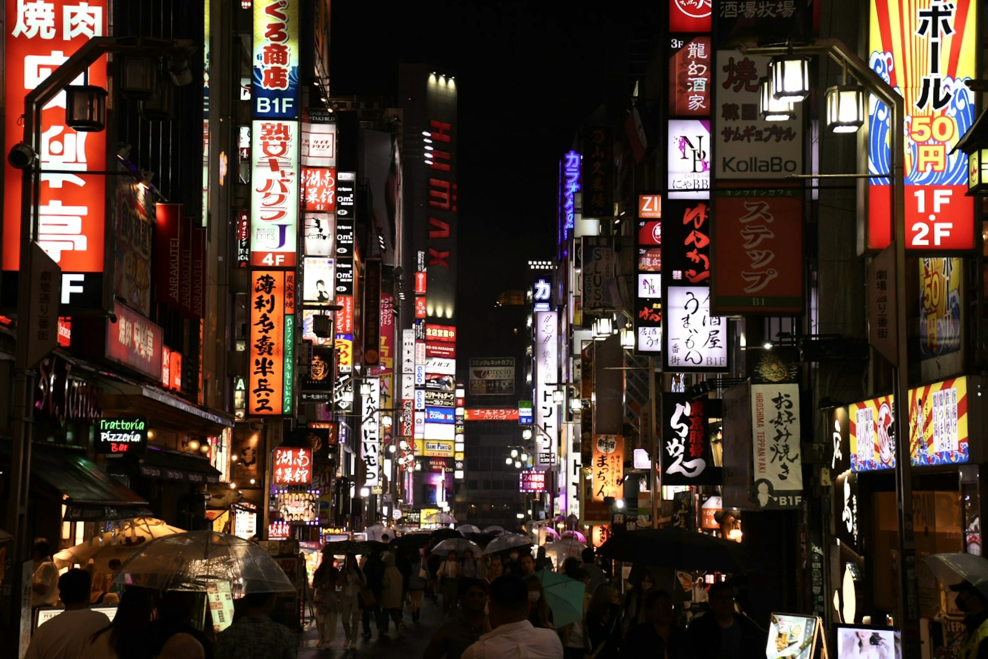 Nighttime street scene in Shinjuku with bright neon signs