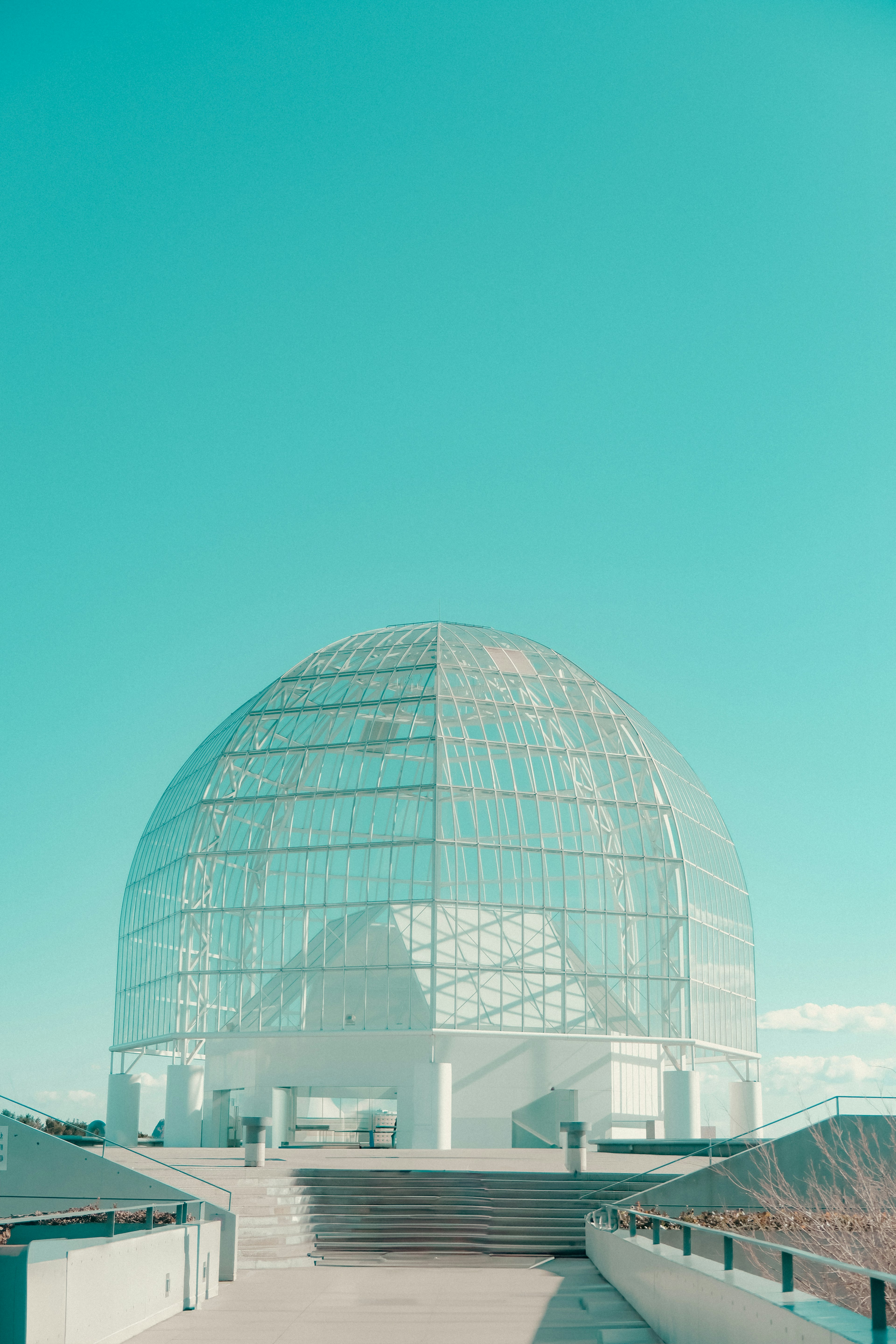 Transparentes kuppelförmiges Gebäude unter einem blauen Himmel