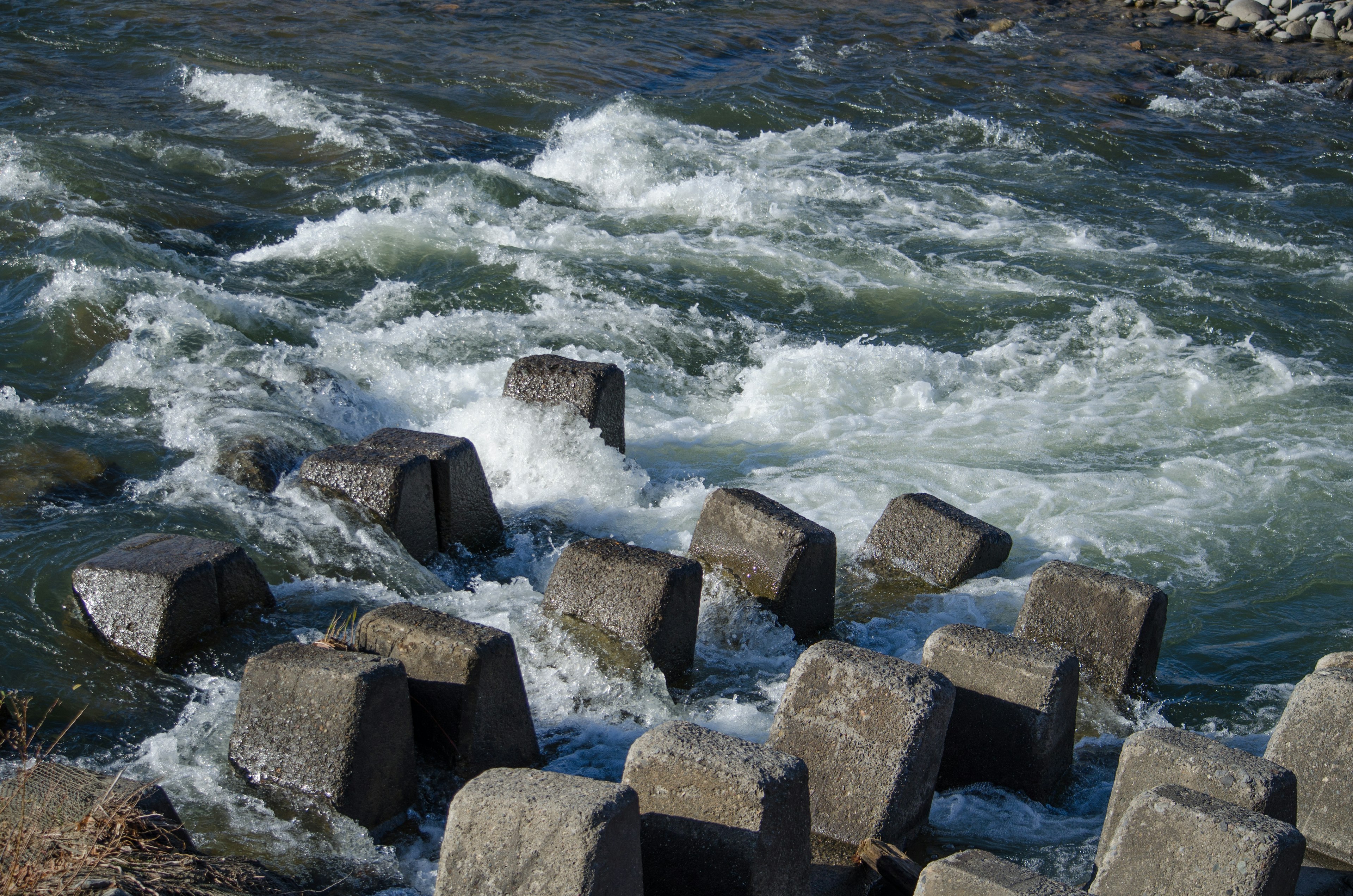 Concrete blocks in a flowing river with turbulent water