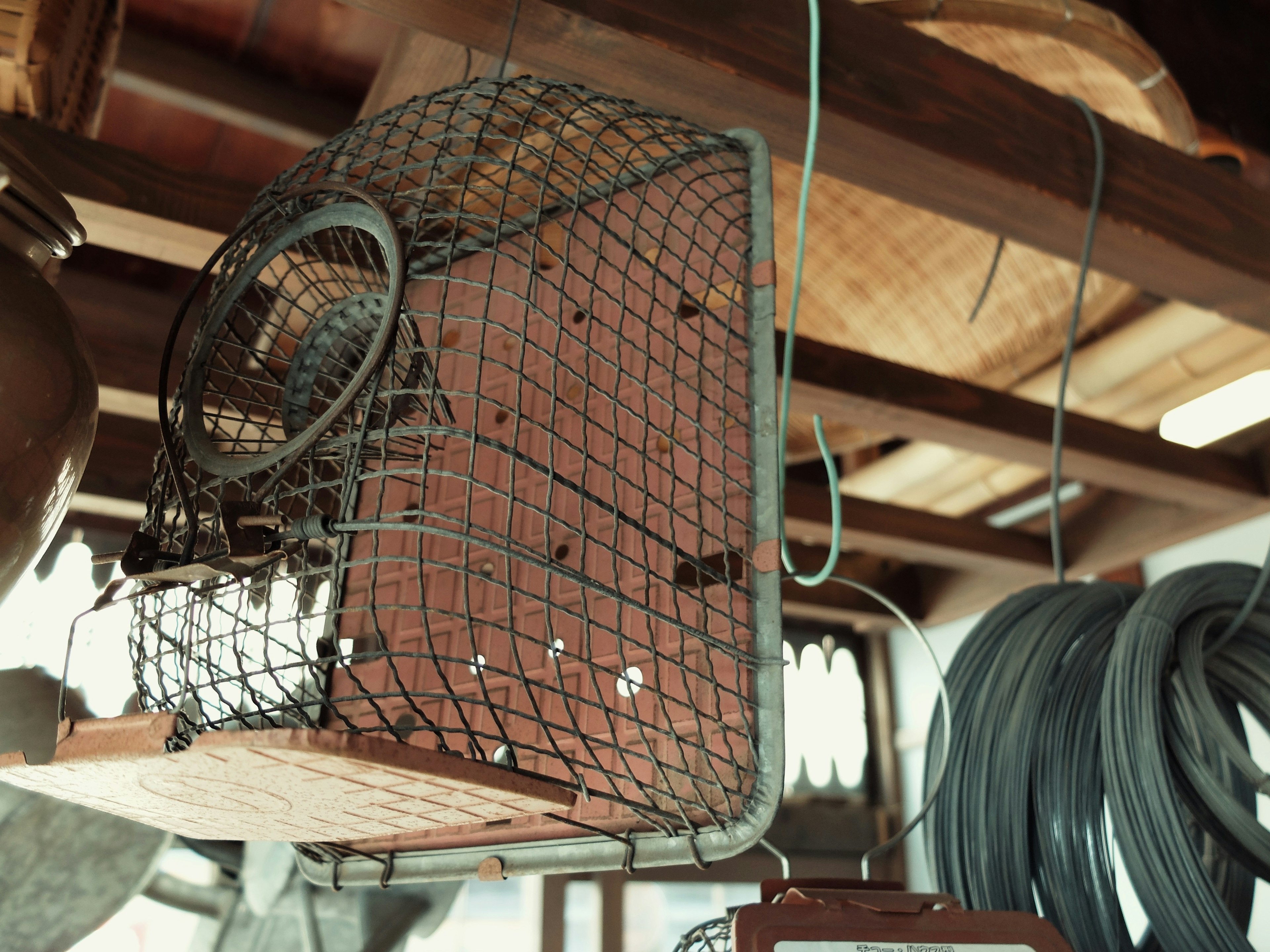 An old metal basket hanging from the ceiling