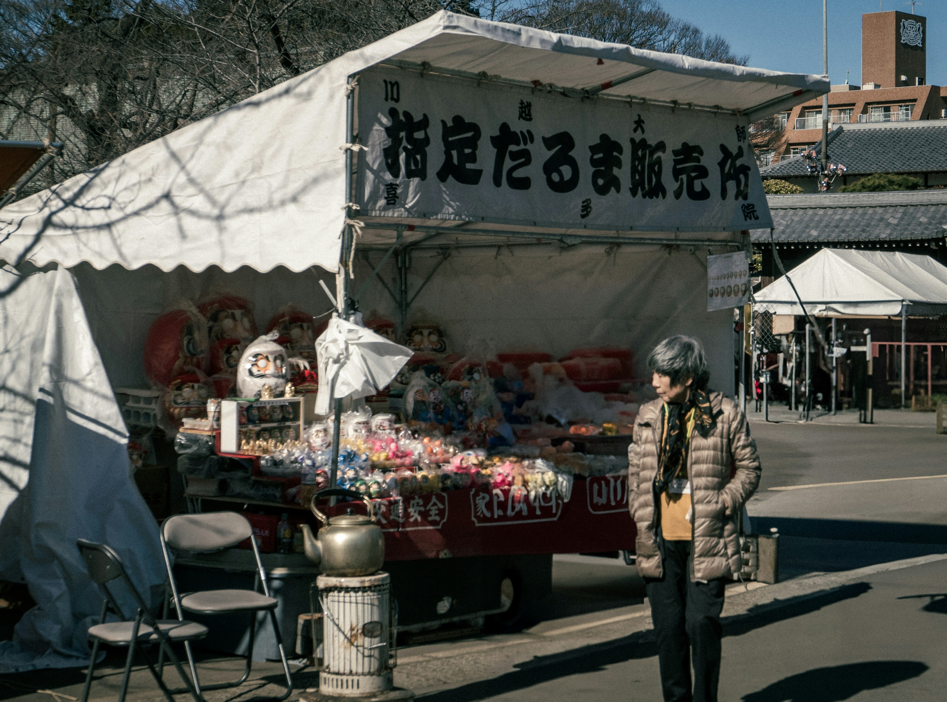 一個人站在一個展示多彩產品的攤位前