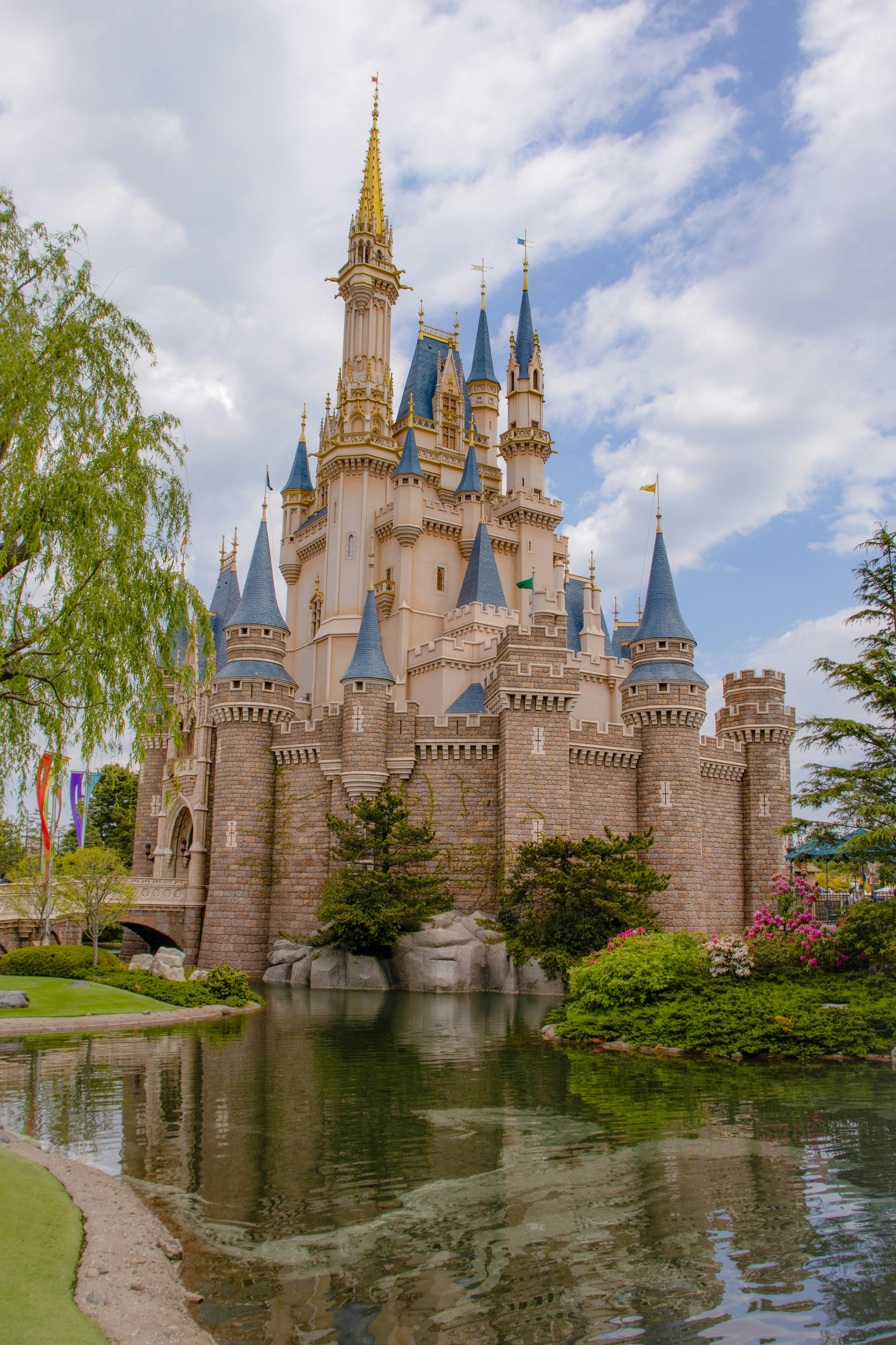 Un beau château avec des flèches entouré de verdure et d'eau