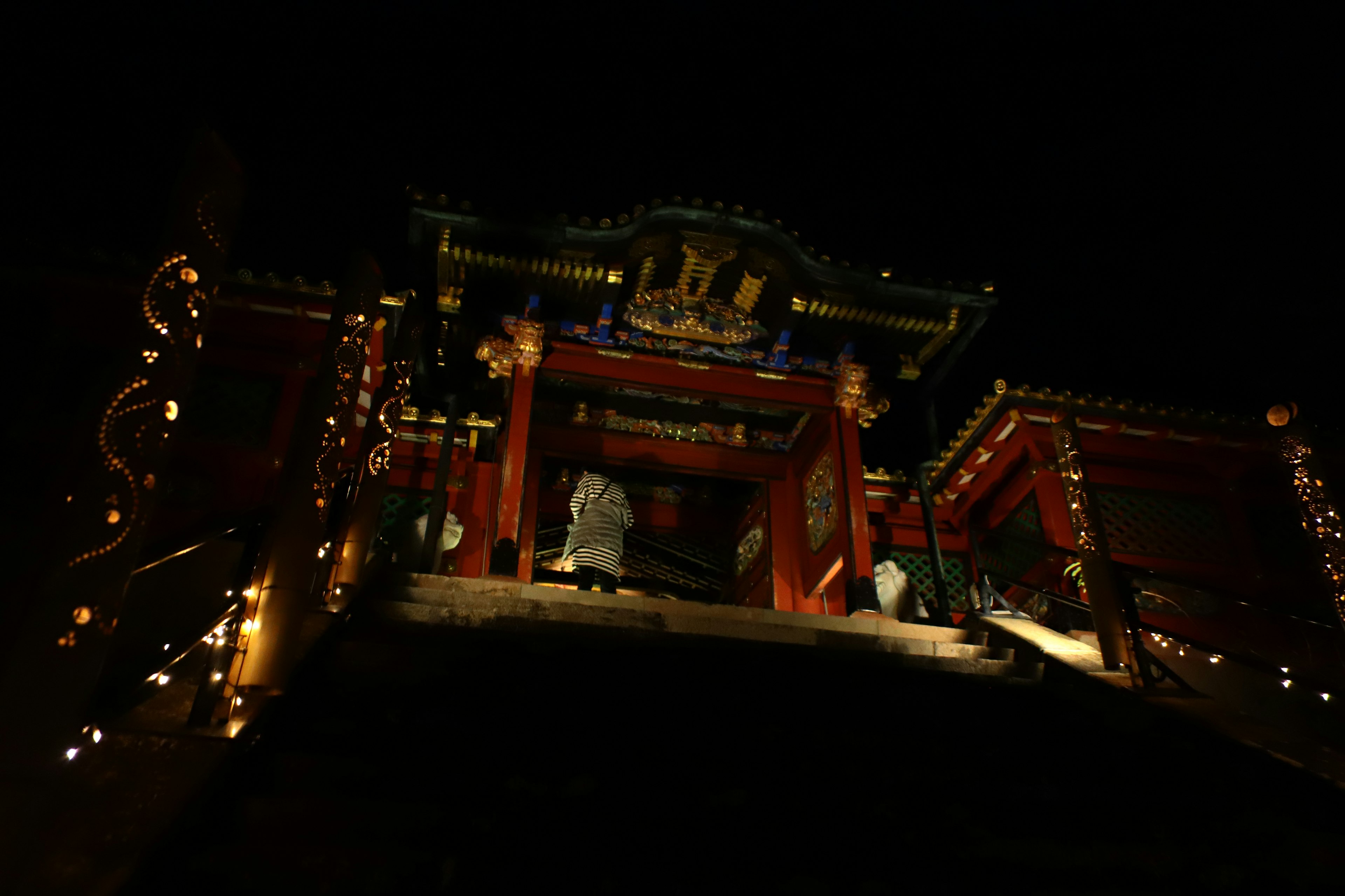 A beautifully illuminated temple staircase at night with decorations