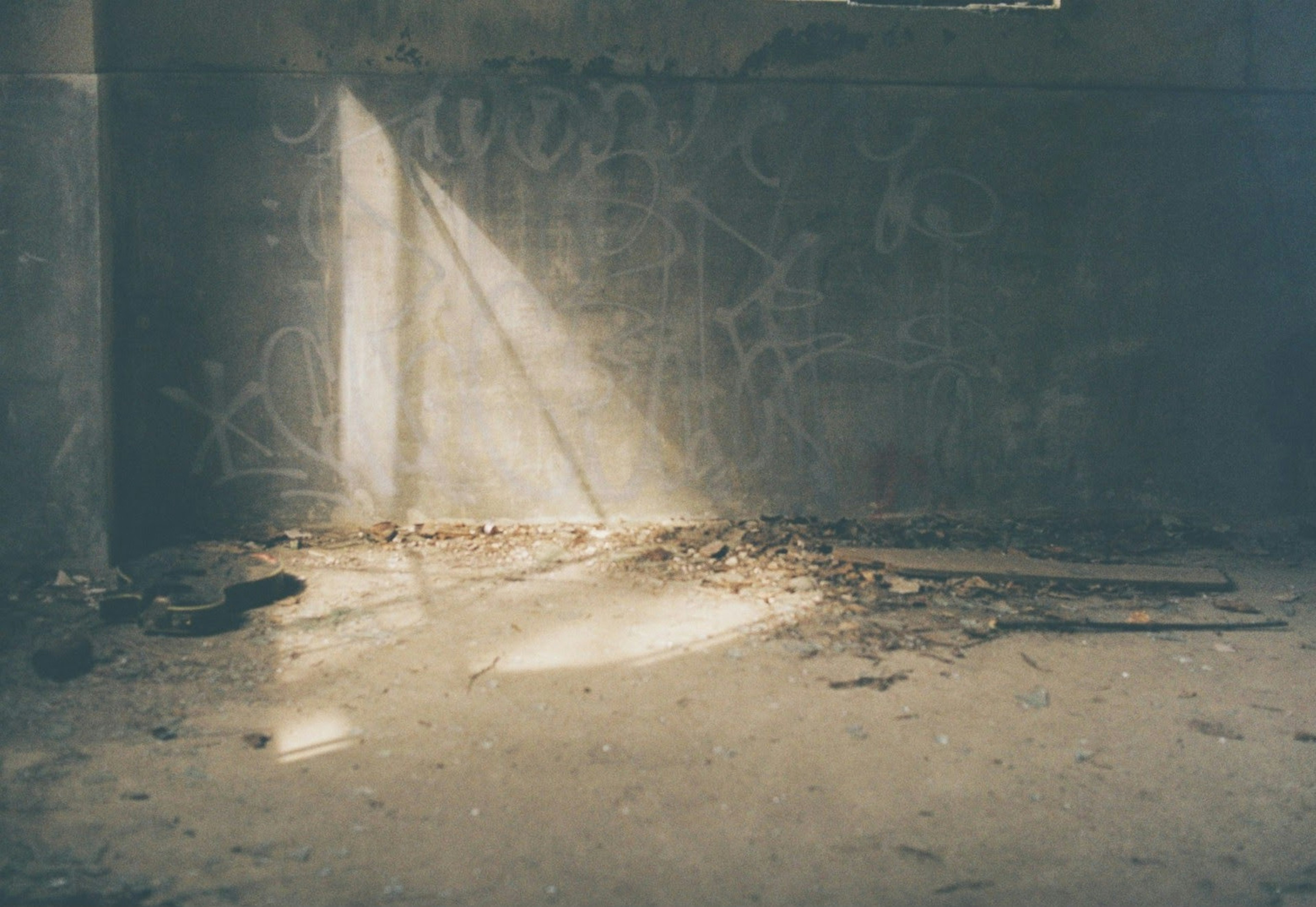 Beam of light in a dim corner of a room with a dirty floor