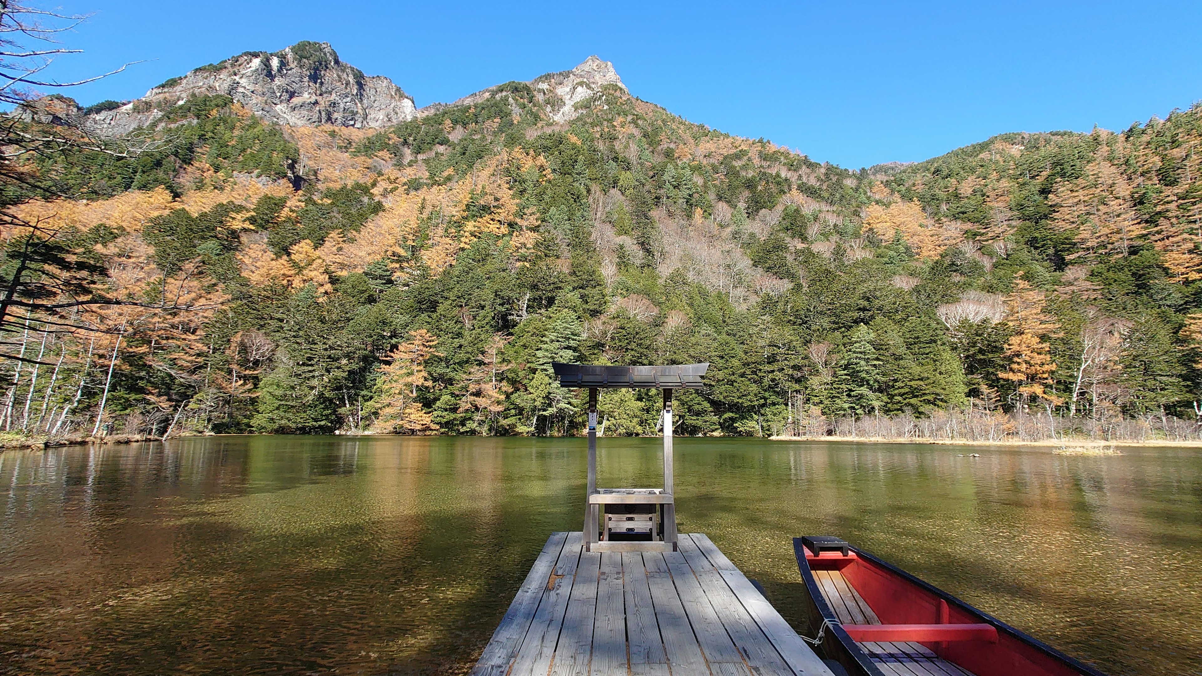 Vue pittoresque d'un lac avec feuillage d'automne et montagnes