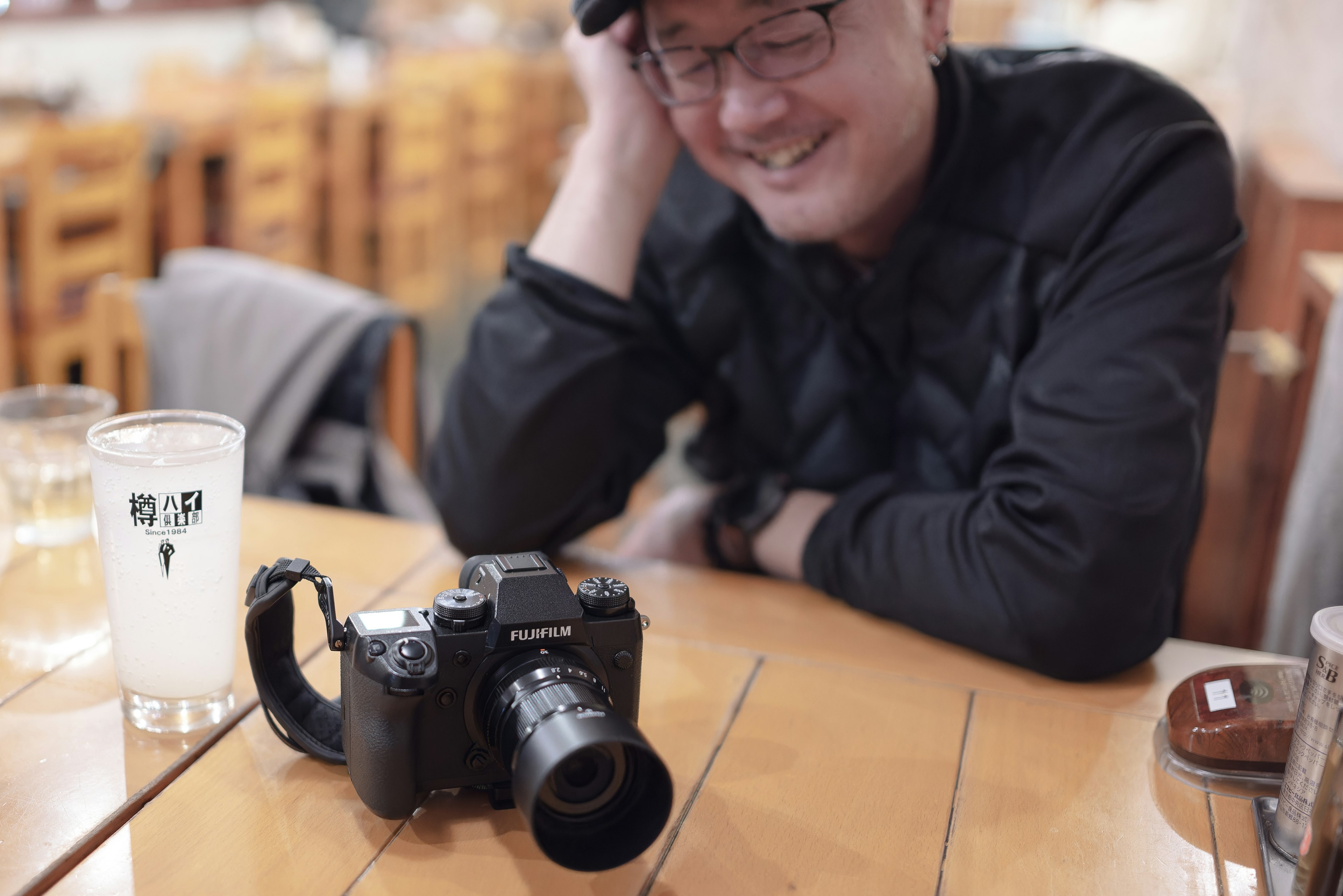 Man smiling while looking at a camera on the table