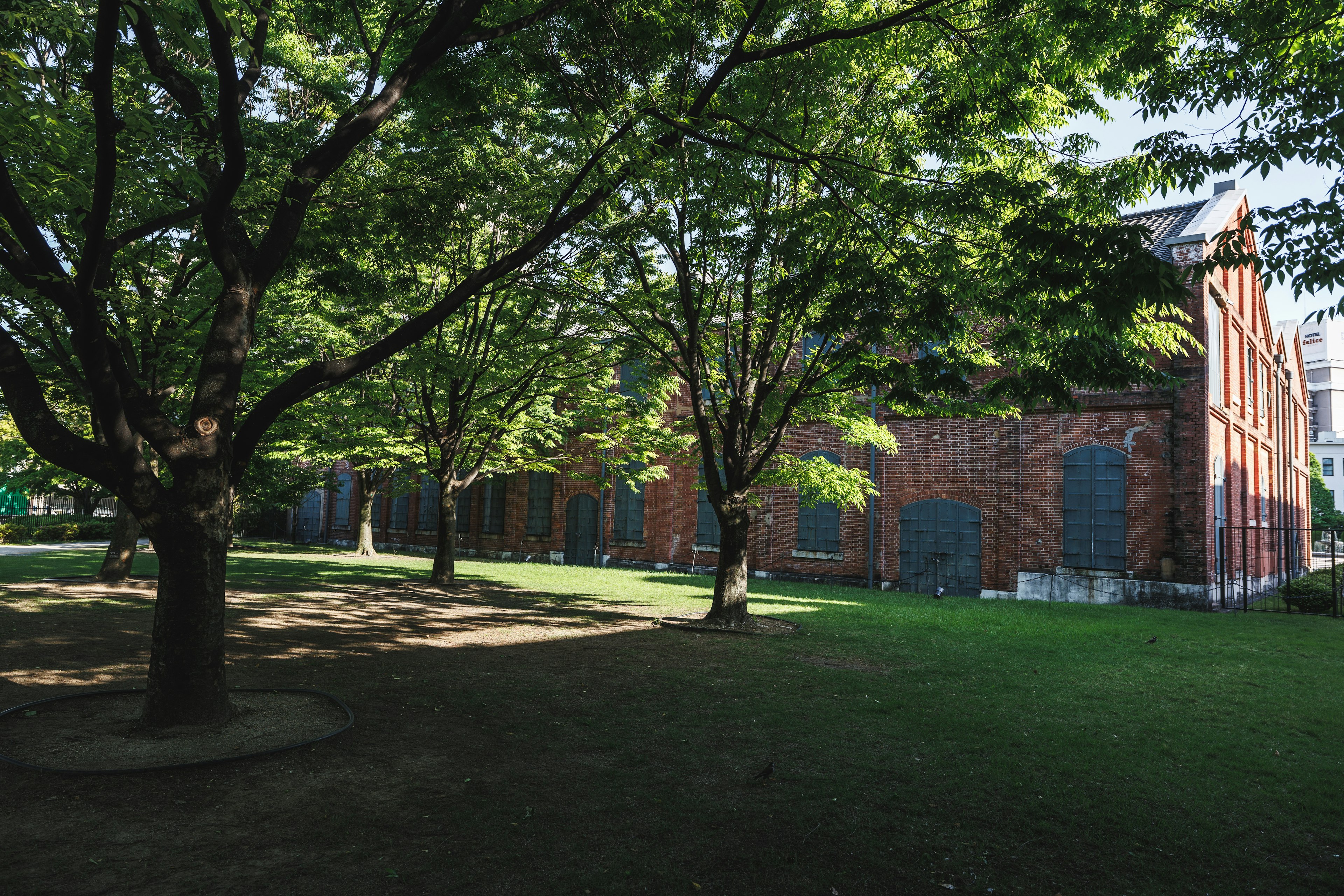 Scenic view of a brick building surrounded by lush green trees