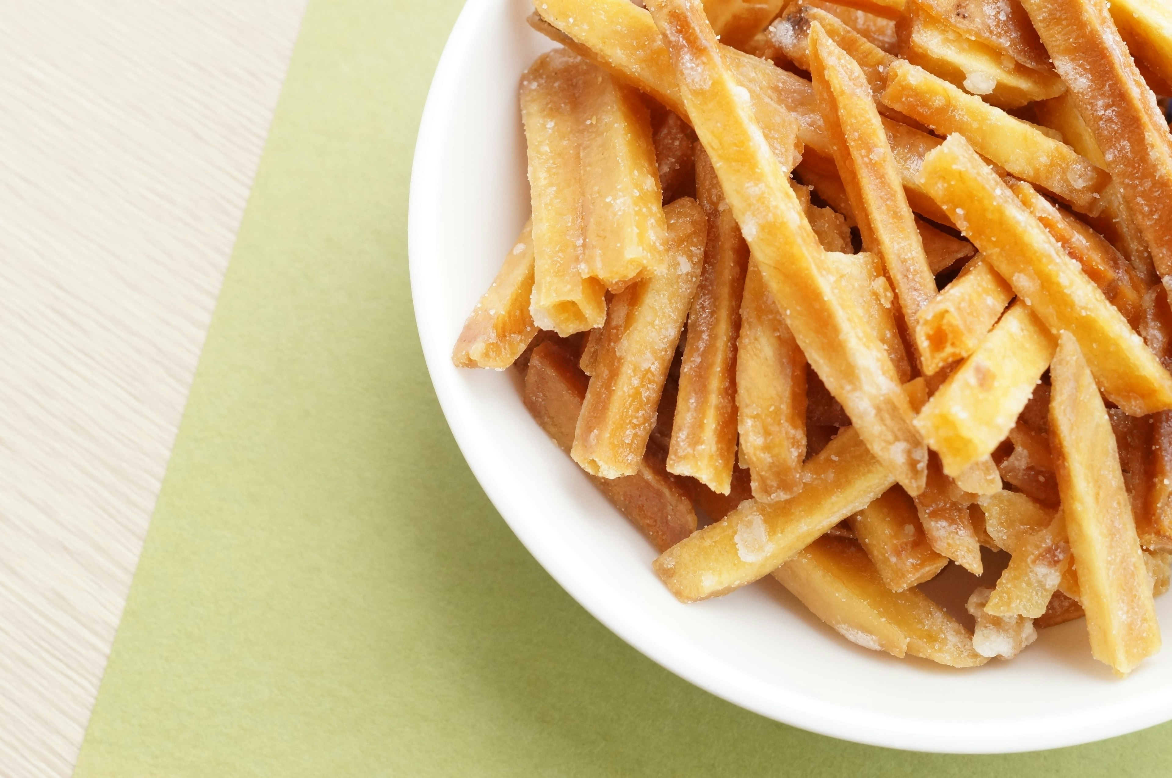 Crispy stick-shaped snacks in a white bowl