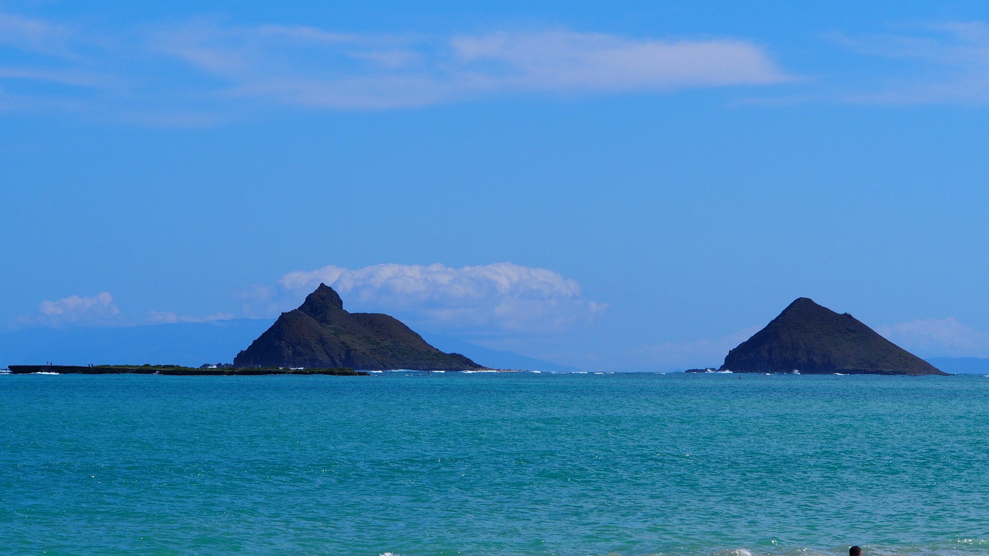 Twin islands of Mokulua in turquoise waters under a clear blue sky