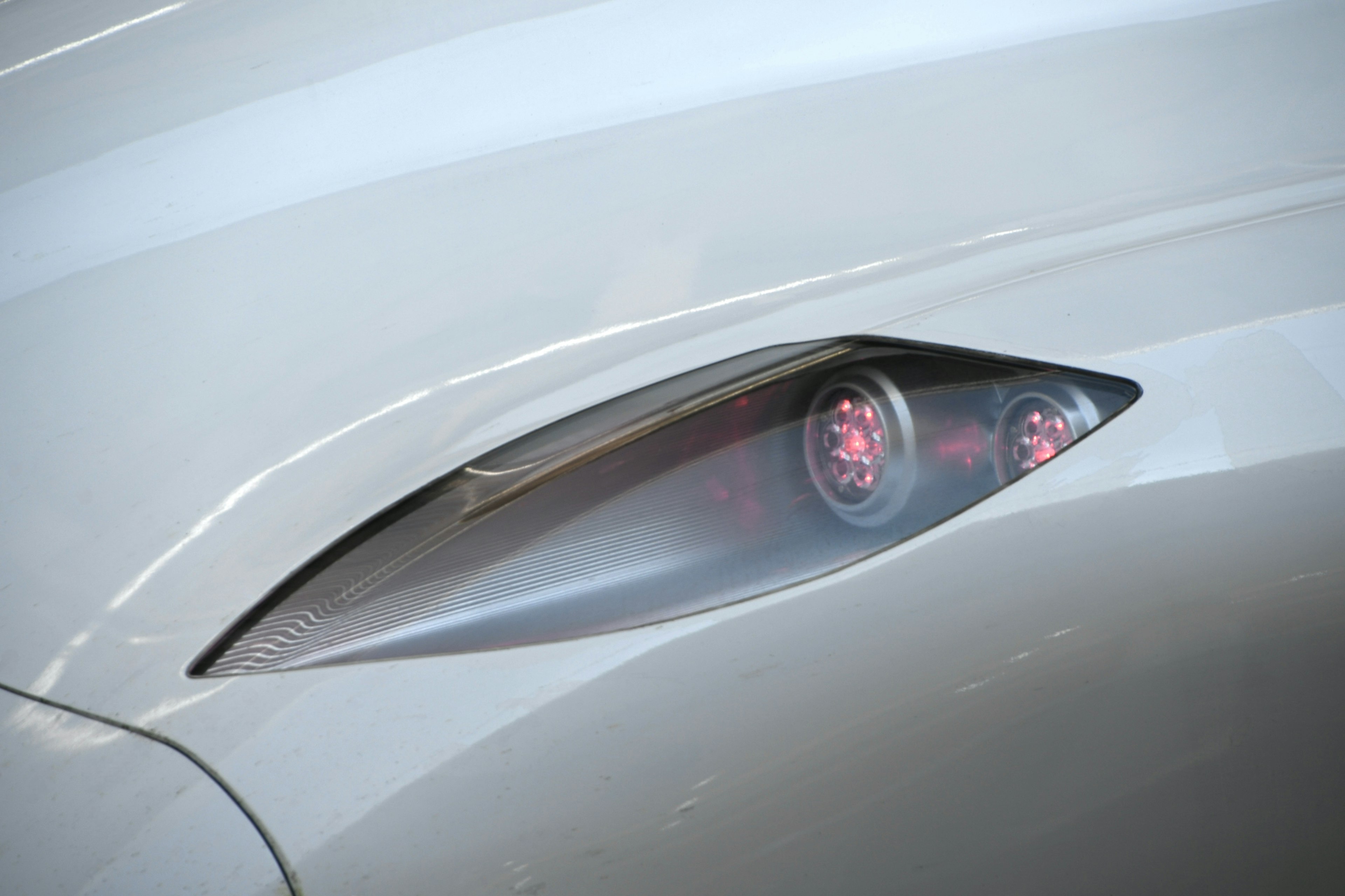 Close-up of a sleek white sports car with distinctive headlights