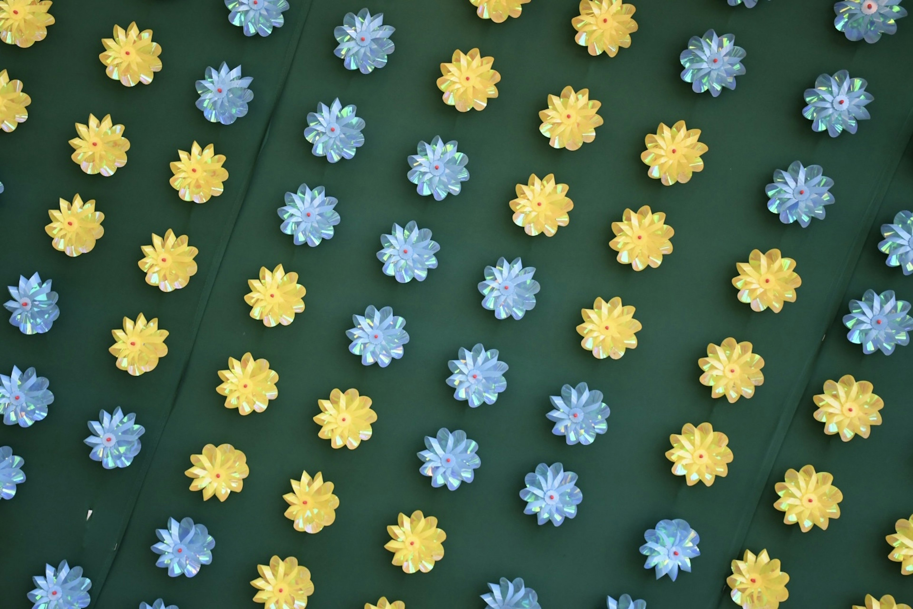 Pattern of blue and yellow flowers scattered on a green background