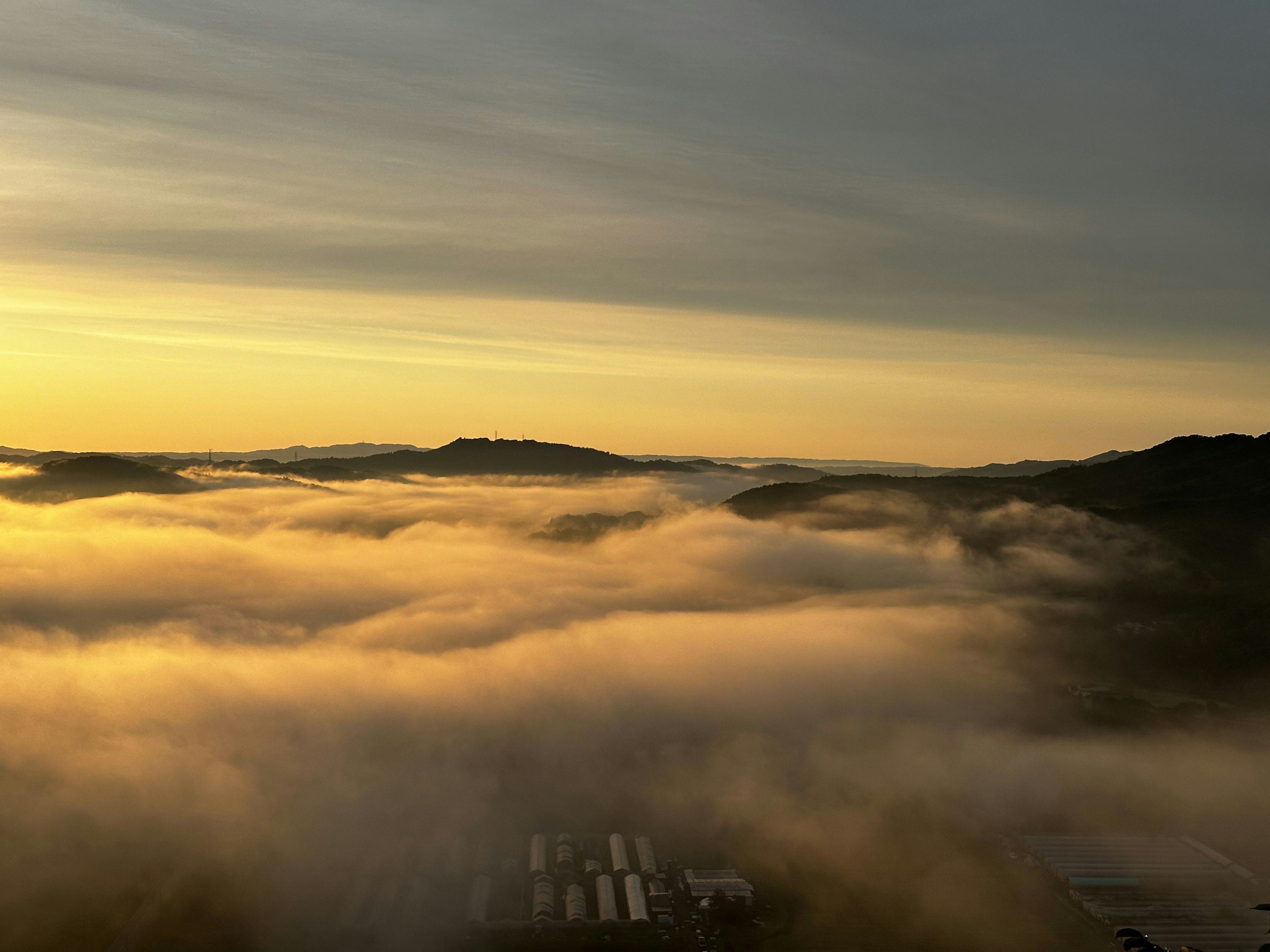 Paisaje cubierto de niebla con un cielo al atardecer