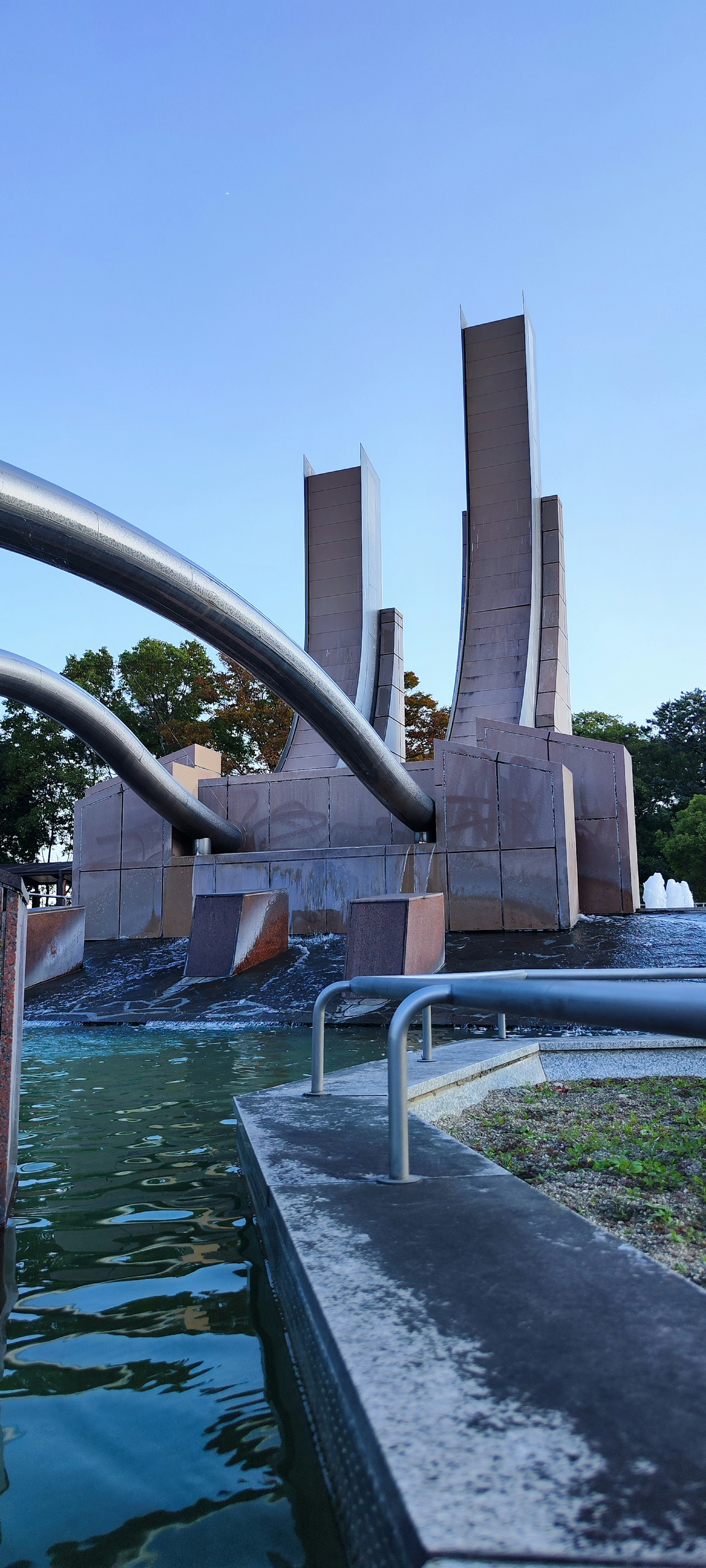 Escultura moderna con agua corriente en la orilla