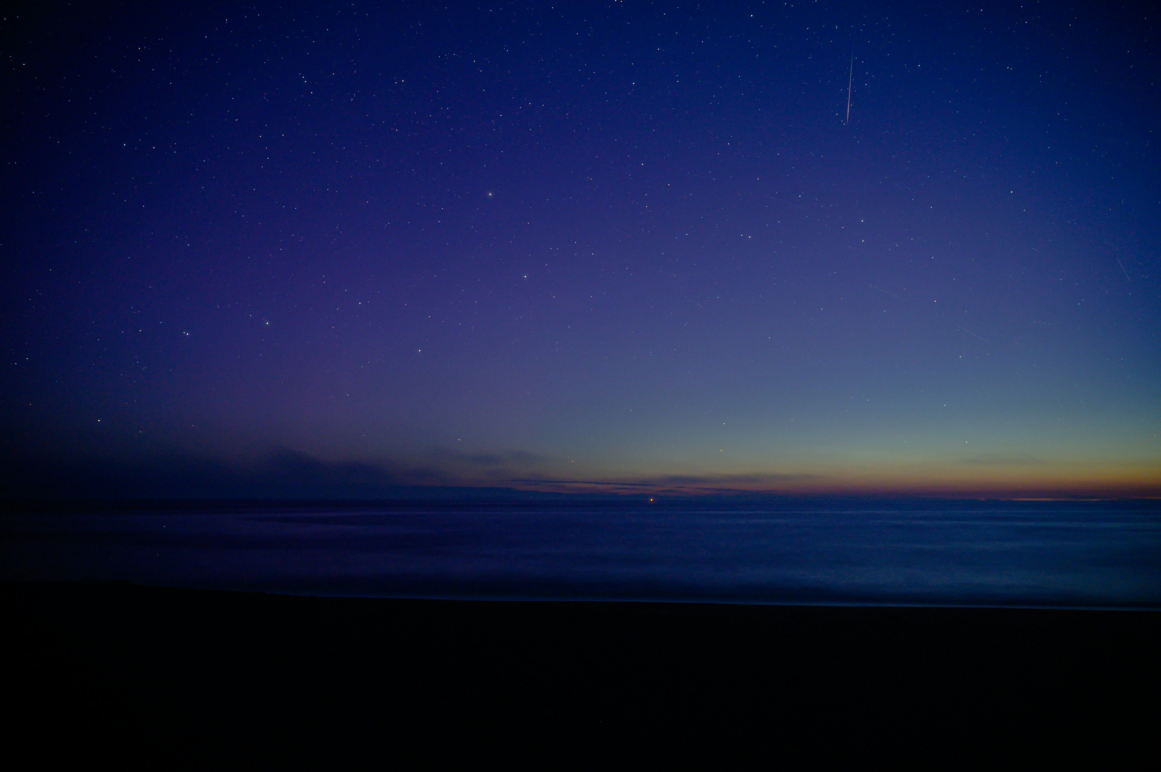 Paesaggio marino sotto un cielo stellato prima dell'alba