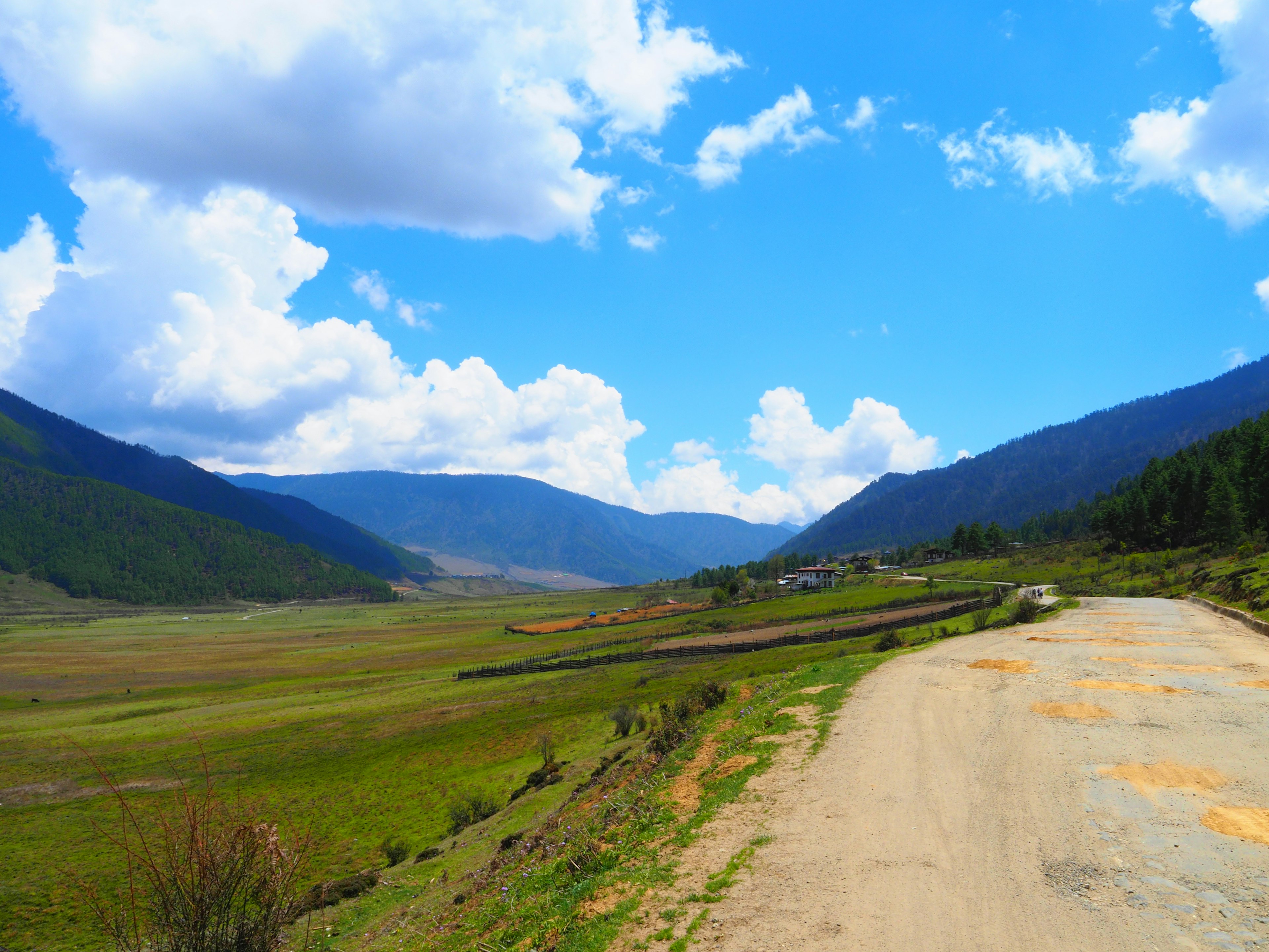 Scenic landscape with blue sky and white clouds mountains and green fields