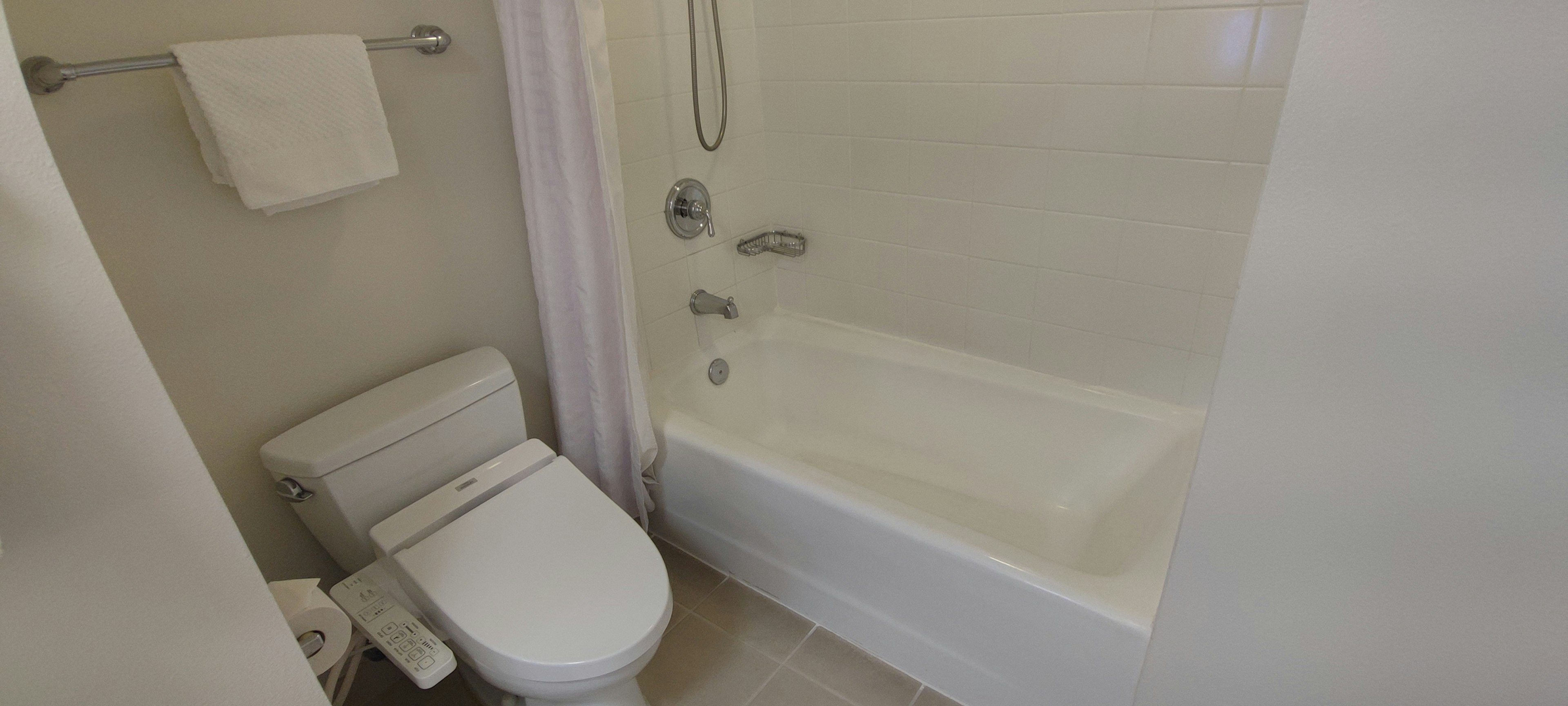 White bathroom featuring a toilet and bathtub