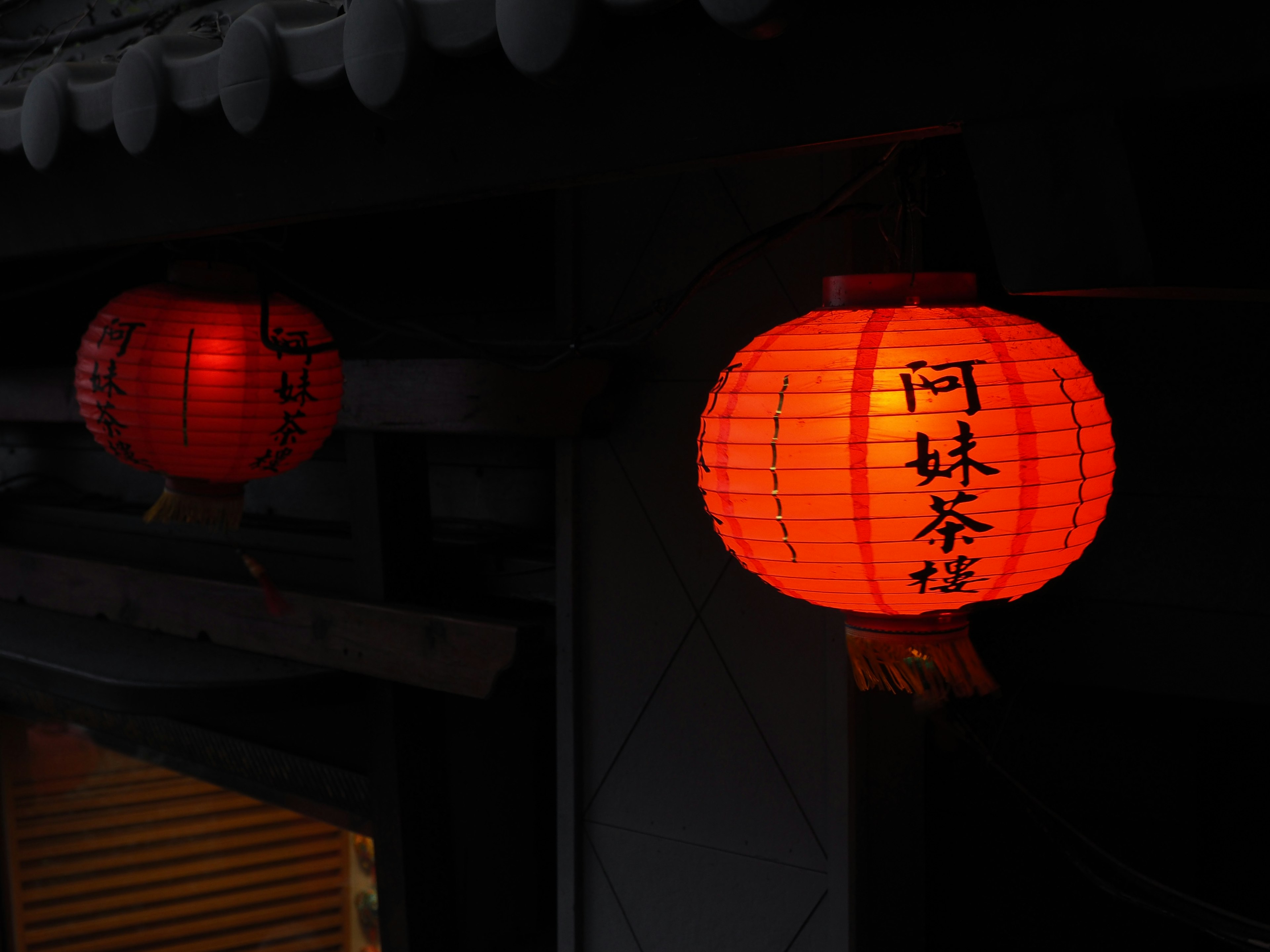 Red paper lanterns glowing against a dark background