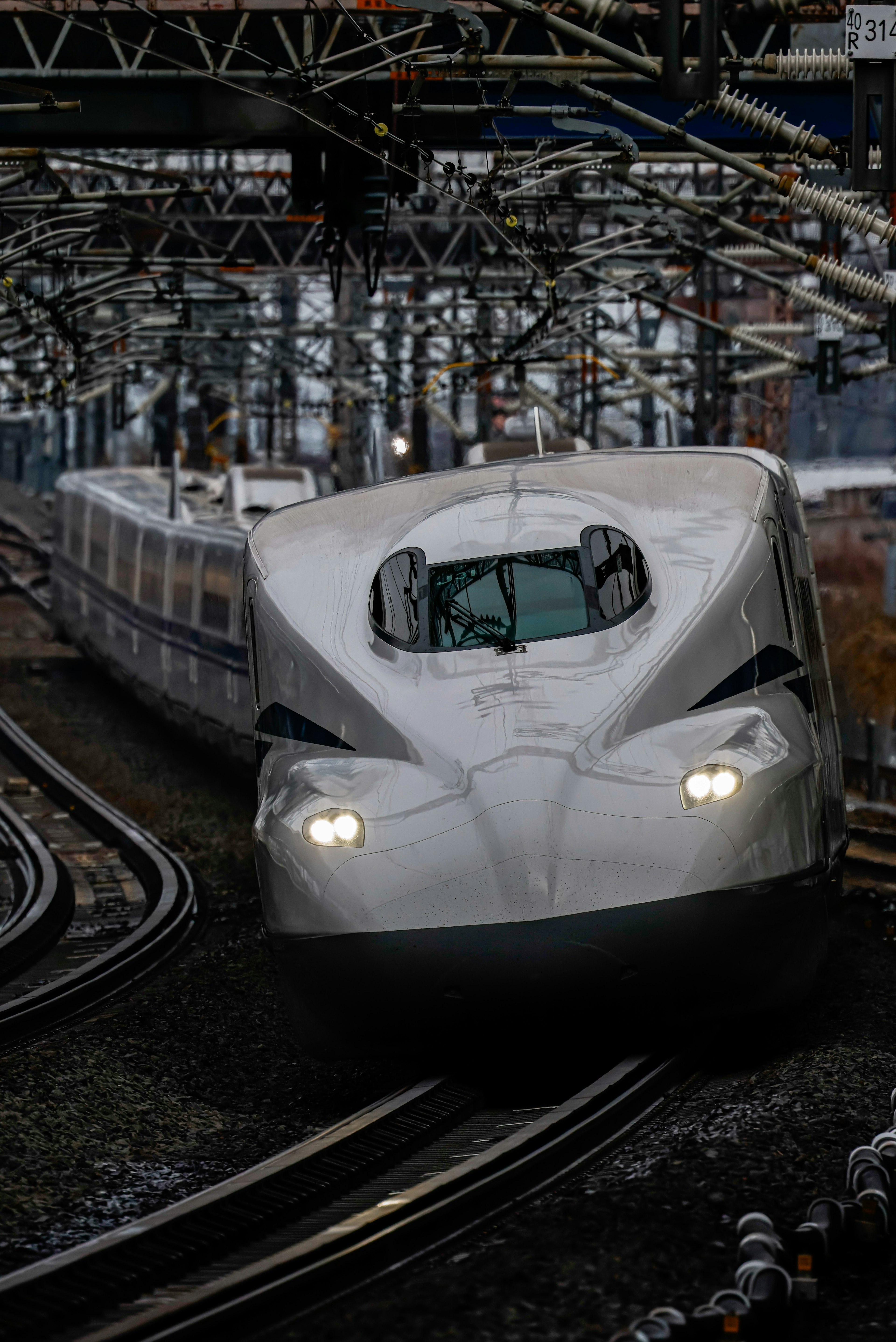 Tren Shinkansen girando en una curva con diseño moderno y faros brillantes