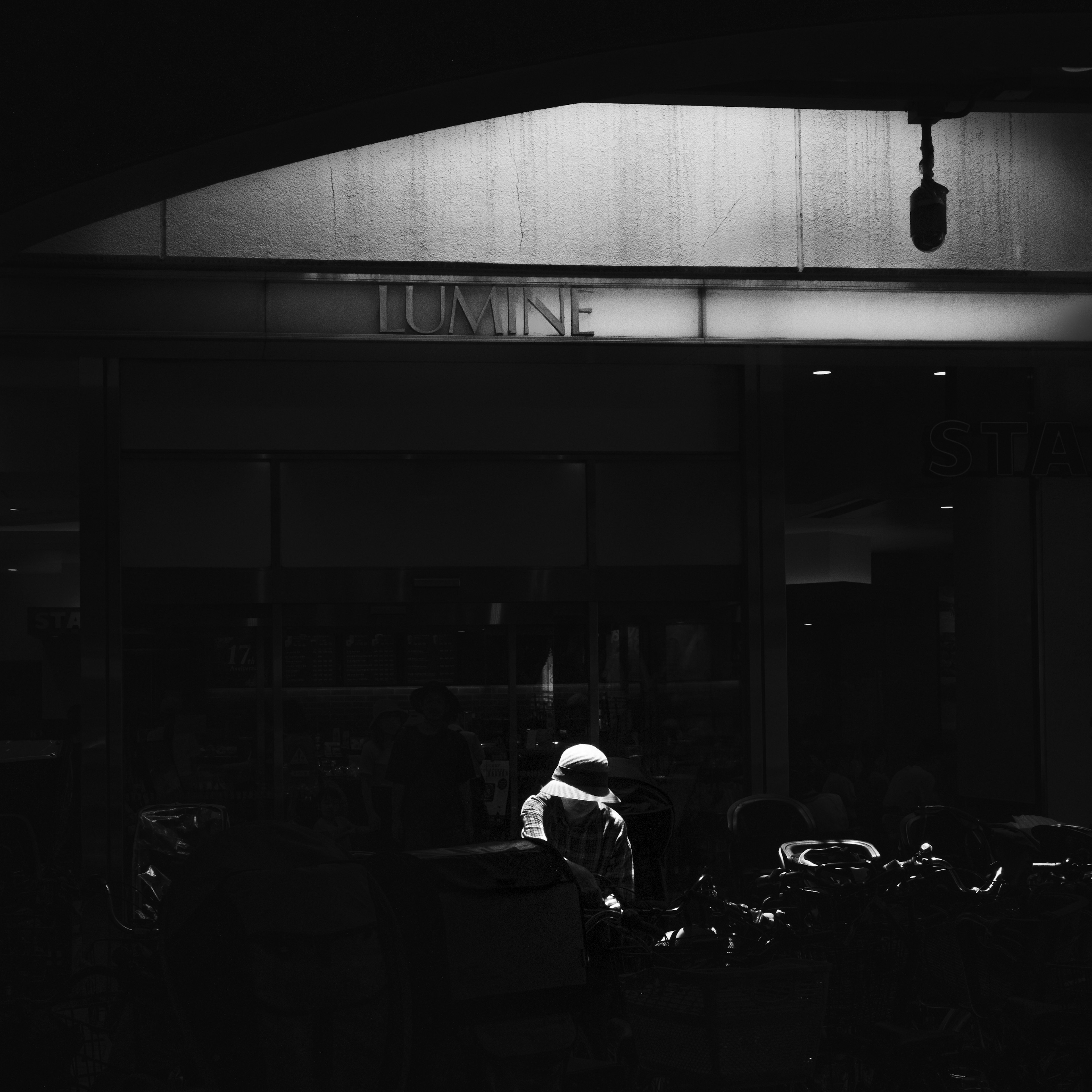 Una scena di strada con una persona in un indumento con cappuccio bianco su uno sfondo scuro