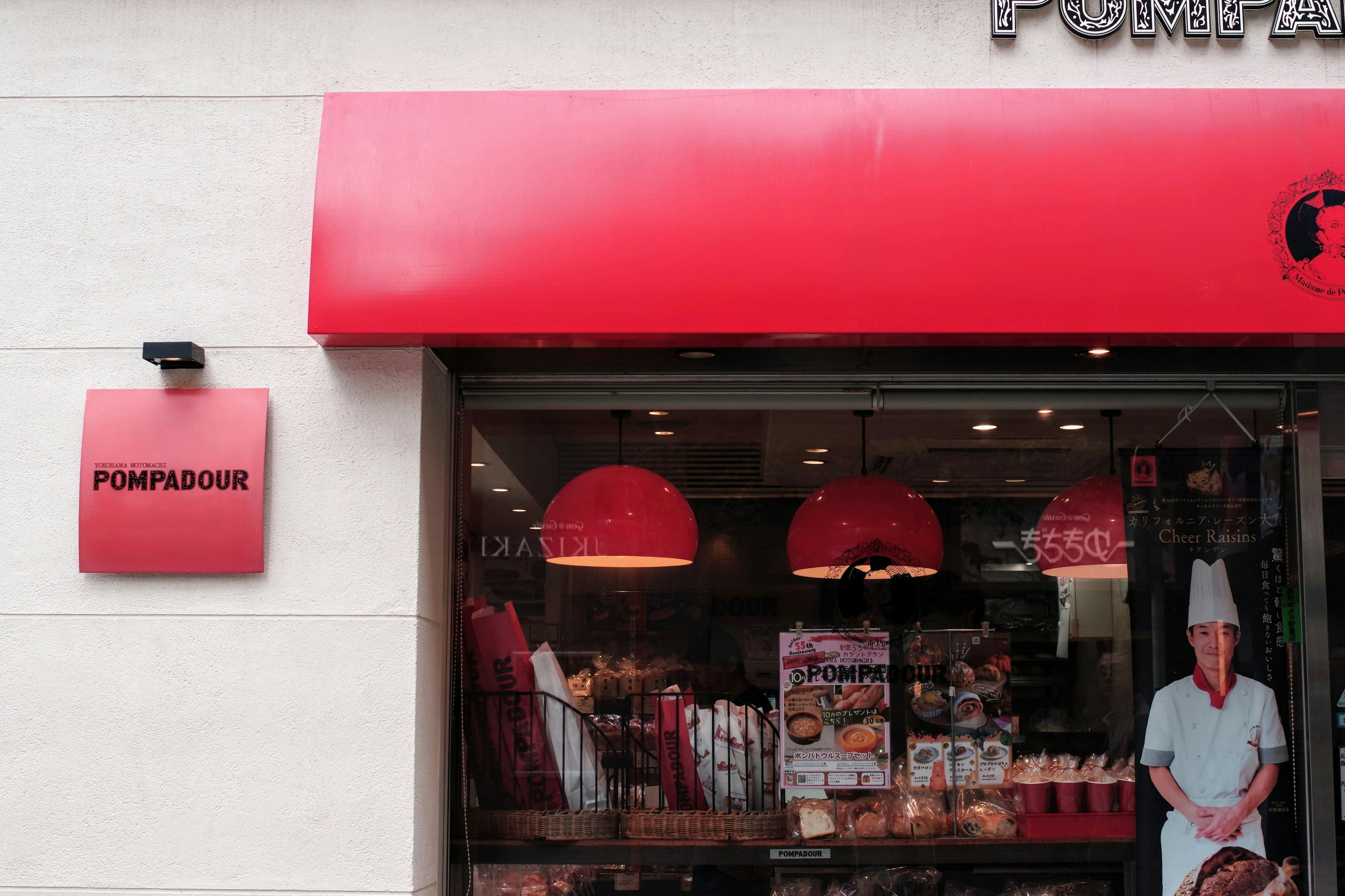 Esterno di una panetteria con un segnale rosso e illuminazione