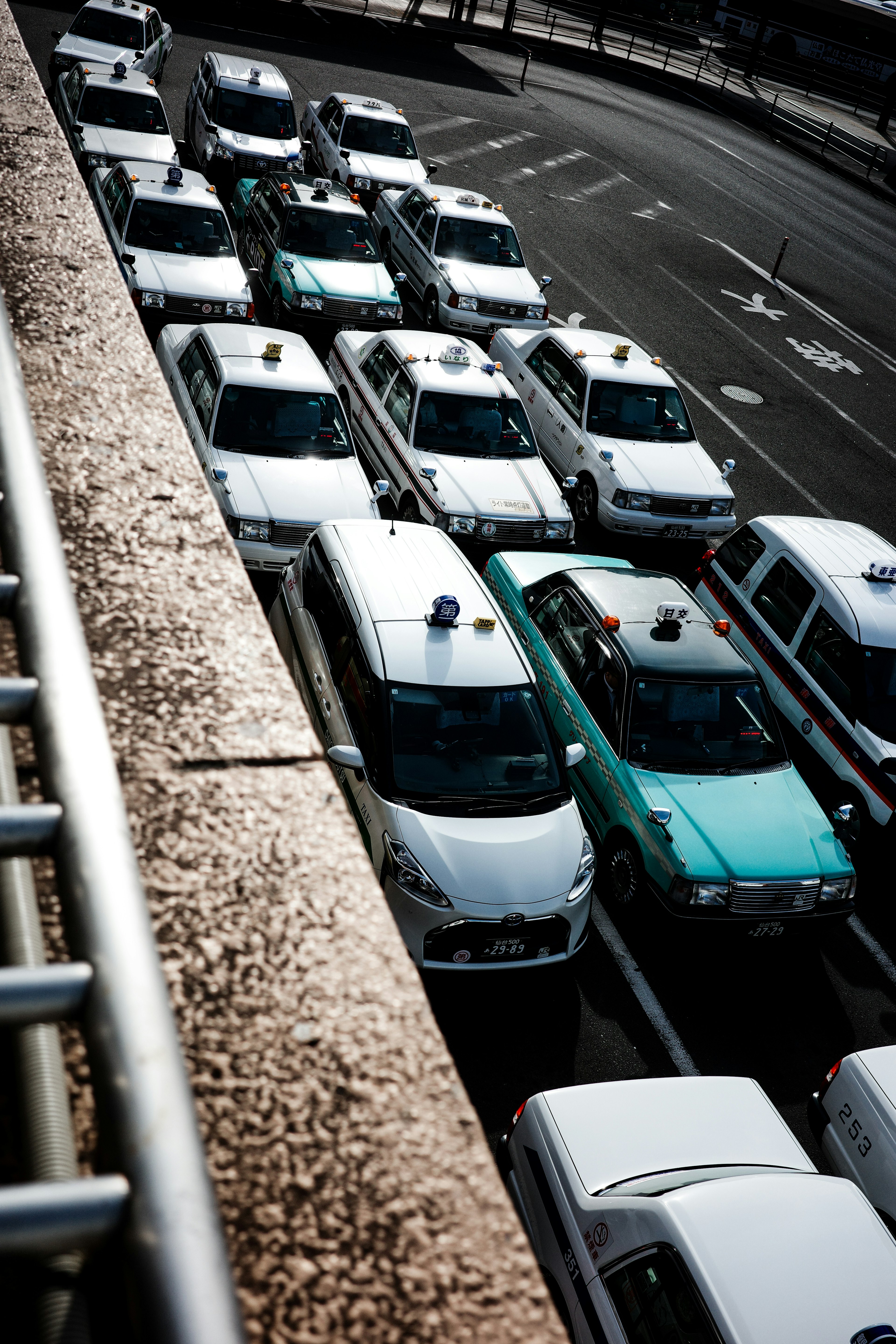 Une file de taxis blancs avec un taxi vert dans un cadre urbain animé