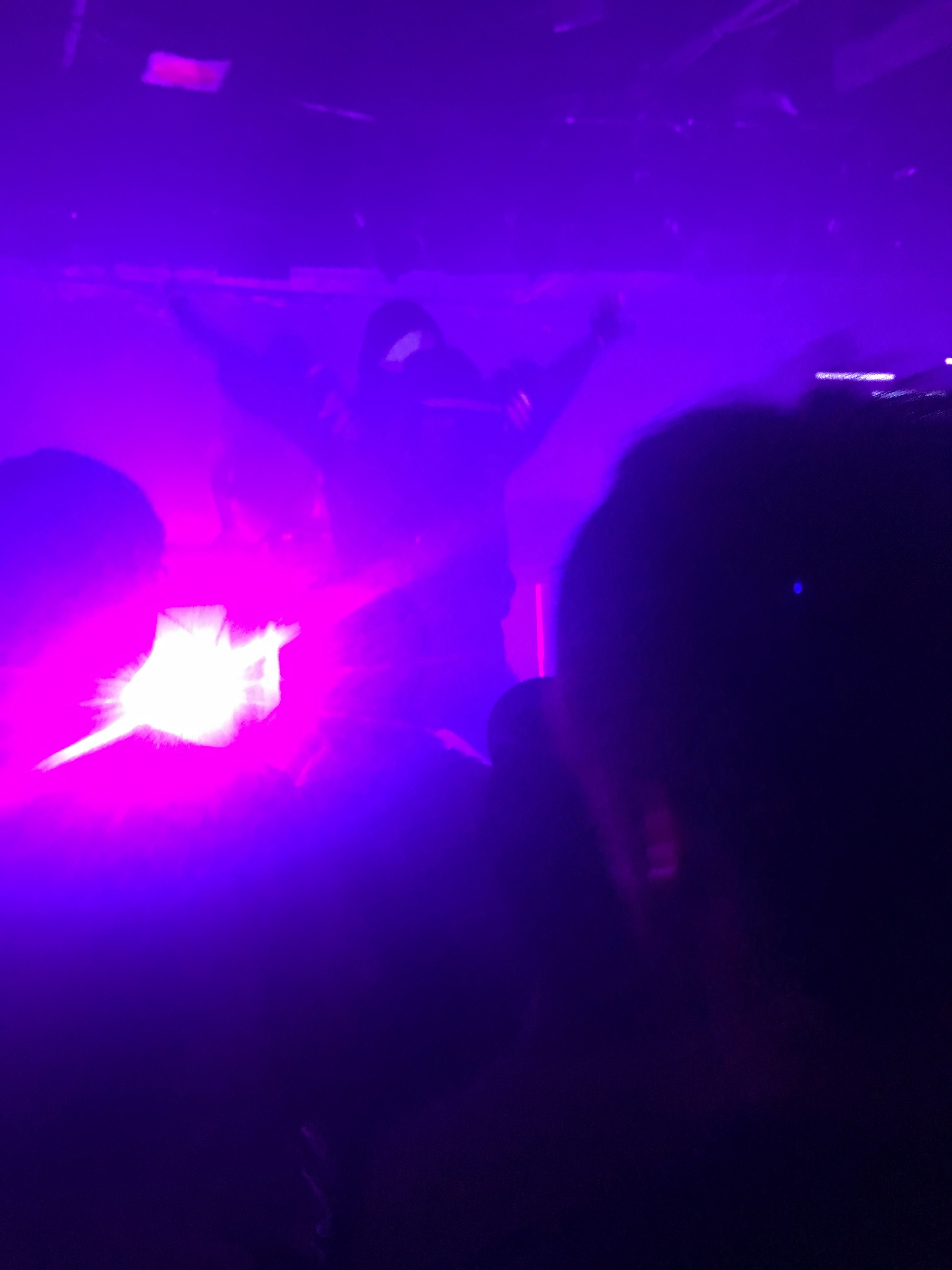 Silhouette performing under purple lighting