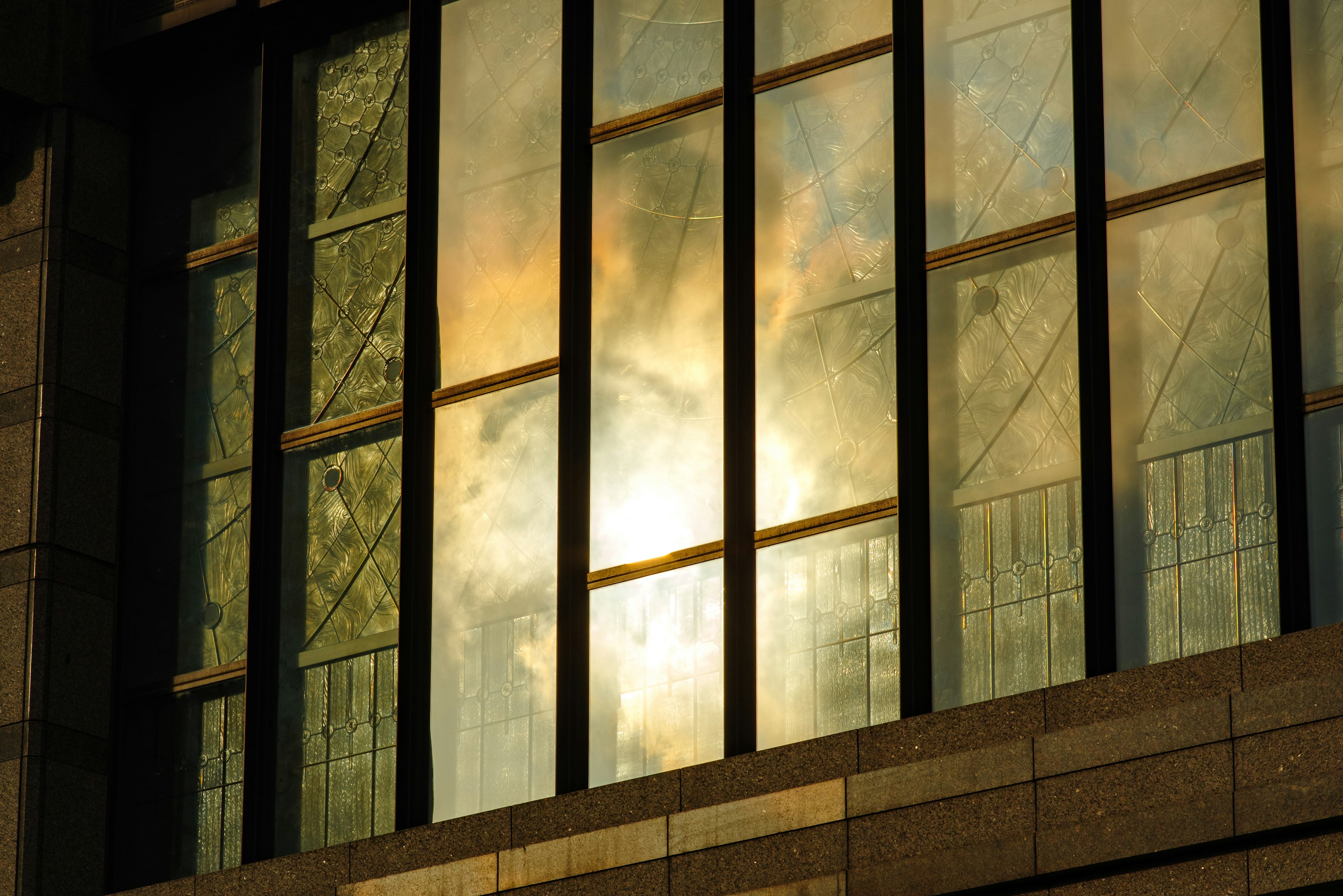 Reflet de la lumière et des nuages sur les fenêtres d'un bâtiment