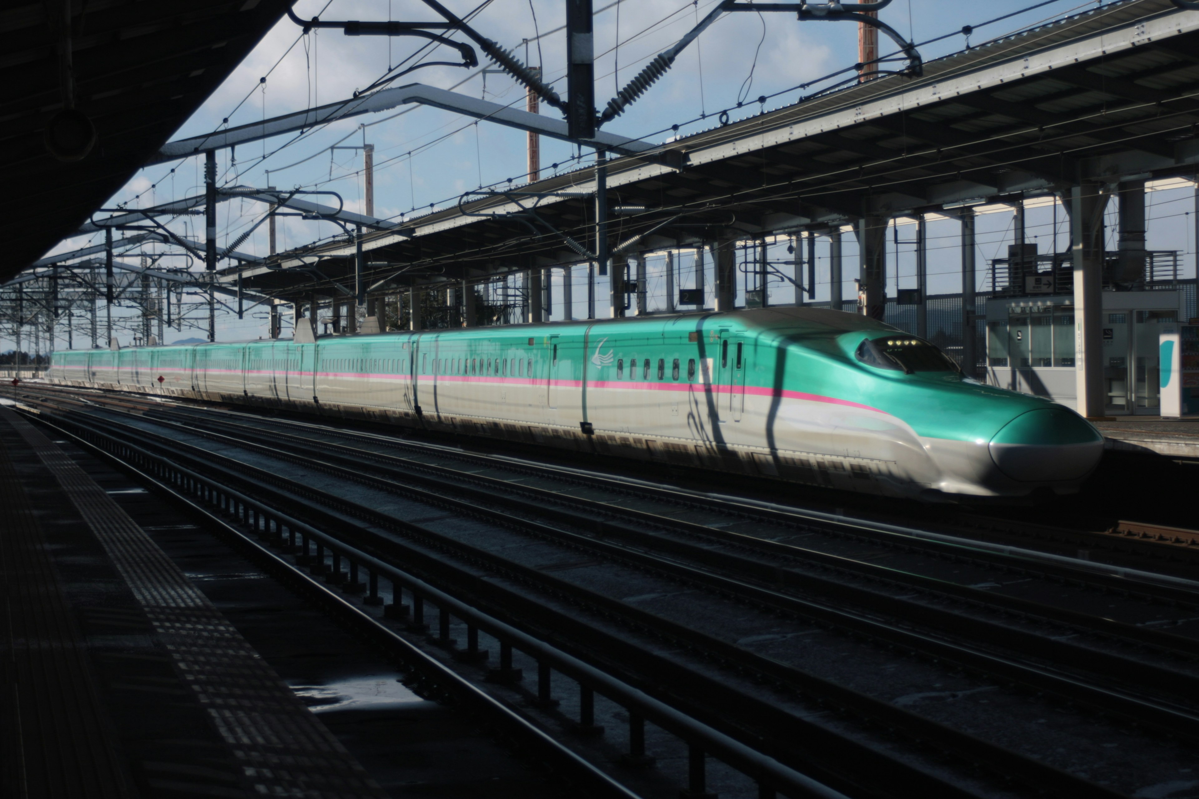 Shinkansen passing through a train station platform