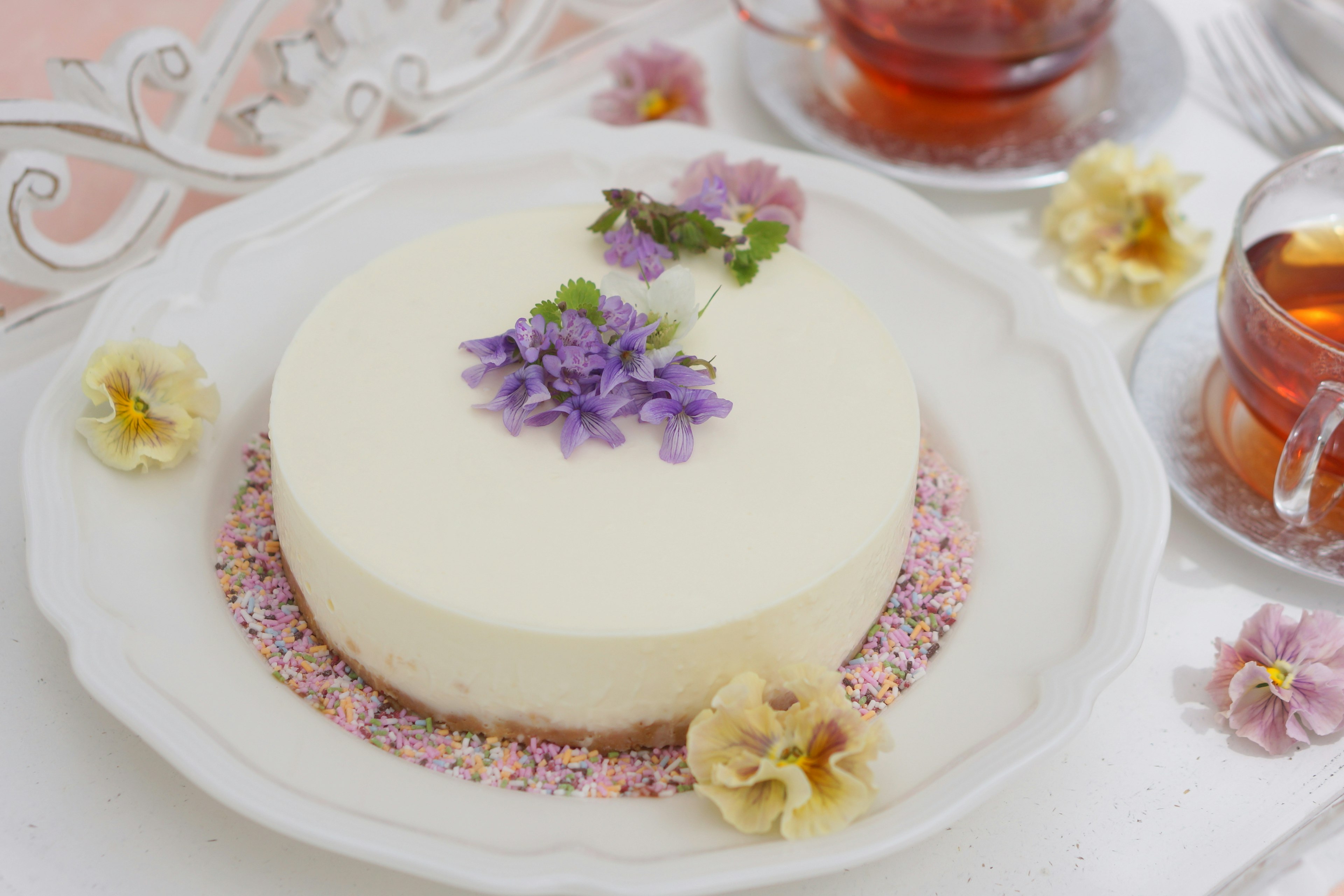 A beautiful white cake adorned with purple flowers